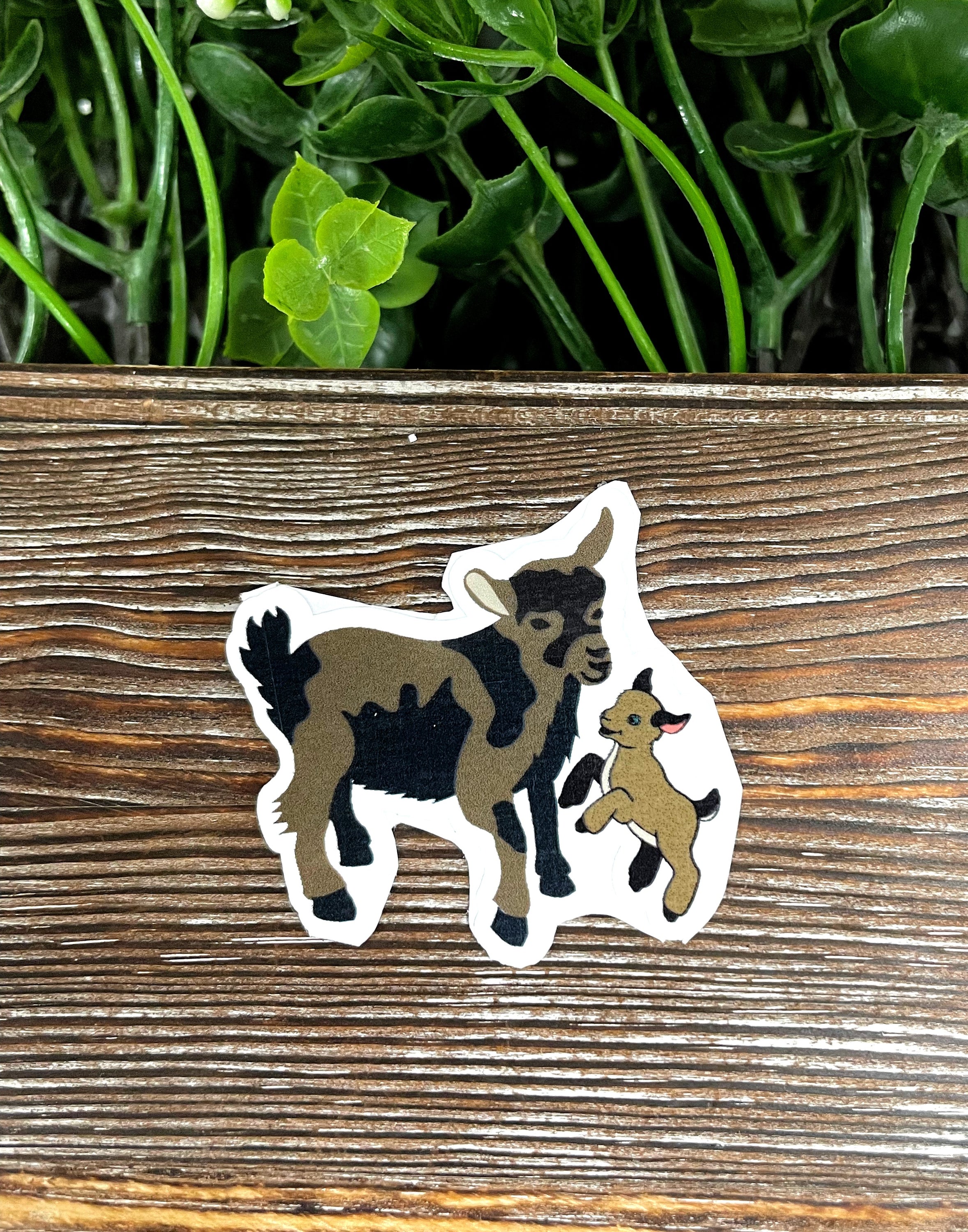 A vibrant sticker featuring a mom and baby Nigerian Dwarf Mini goat, showcasing their adorable features and playful nature.