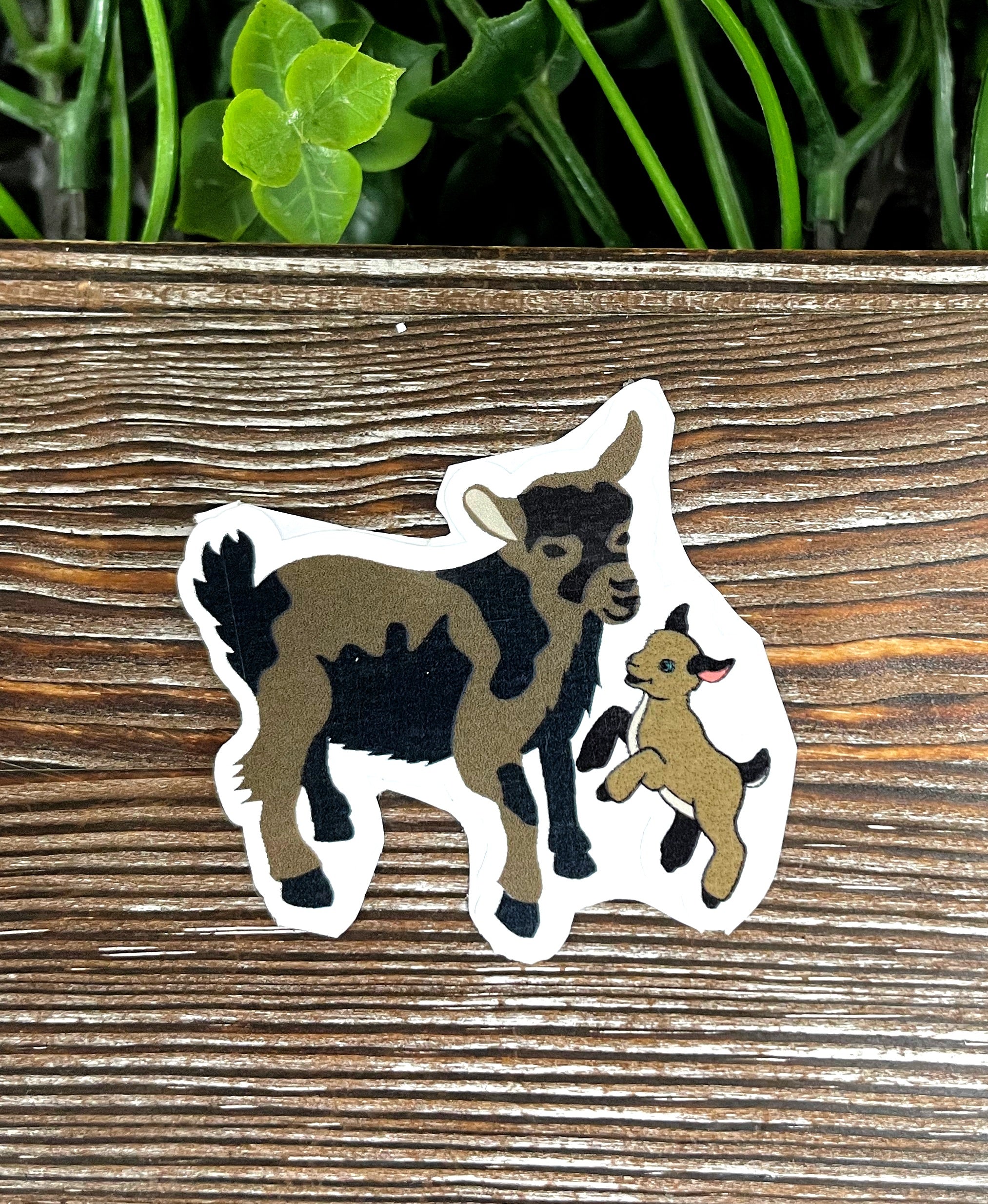 A vibrant sticker featuring a mom and baby Nigerian Dwarf Mini goat, showcasing their adorable features and playful nature.