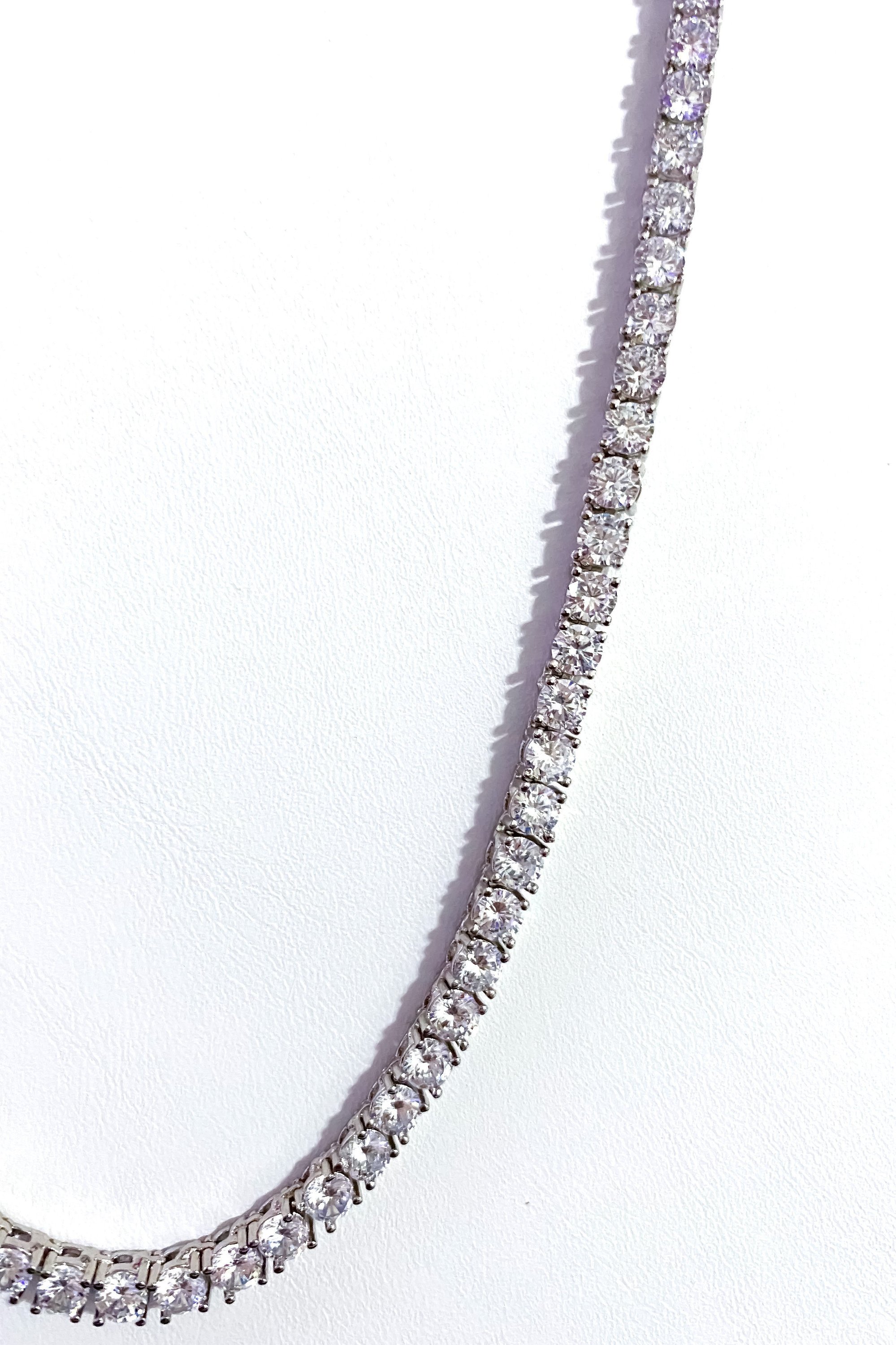 So Icy Tennis Necklace featuring a 4mm row design in high polished 14K white gold with flawless VVS simulants, available in silver and gold.