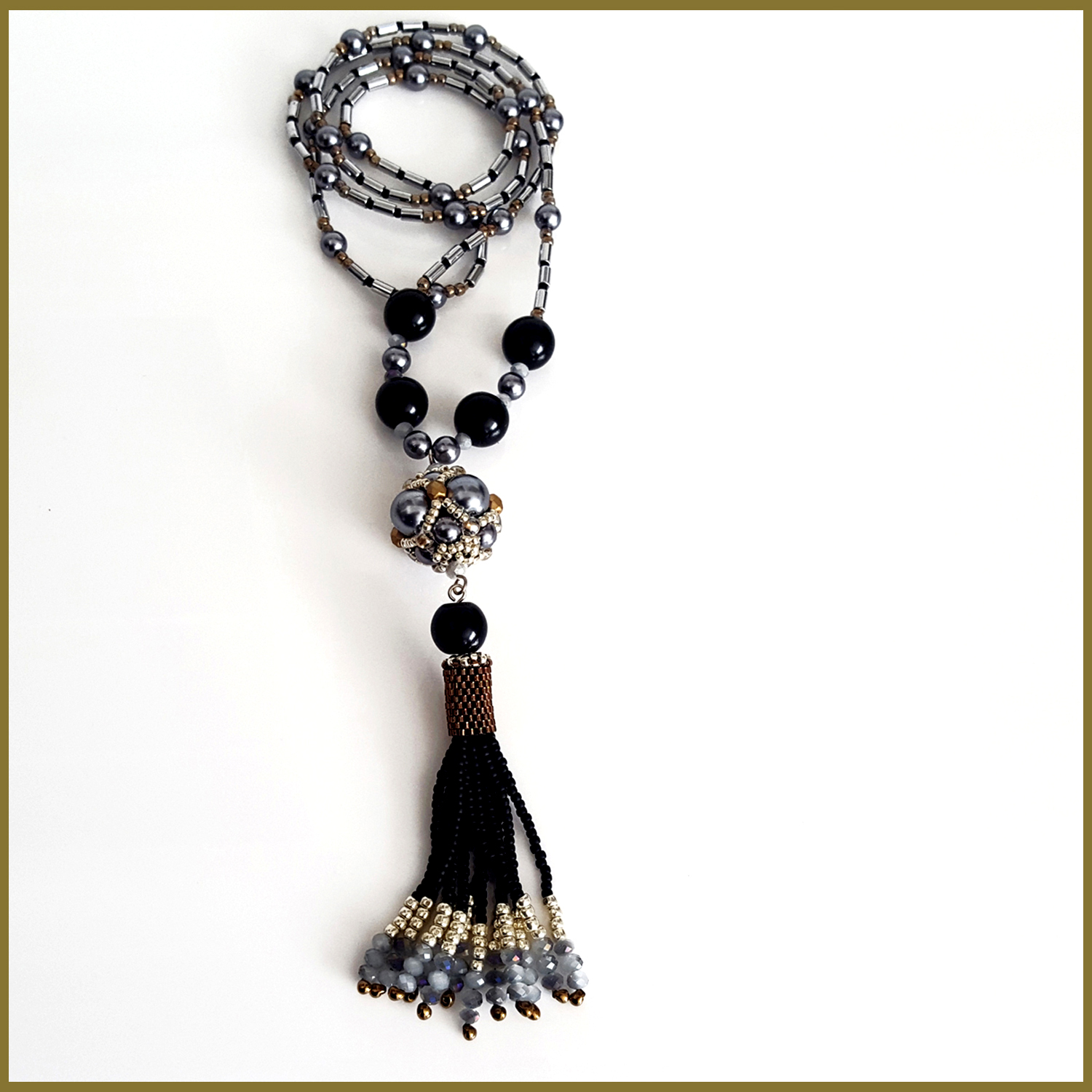 A stunning black beaded tassel necklace featuring silver hematite tubes, handmade with Toho and Delica seed beads, showcasing a boho chic design.