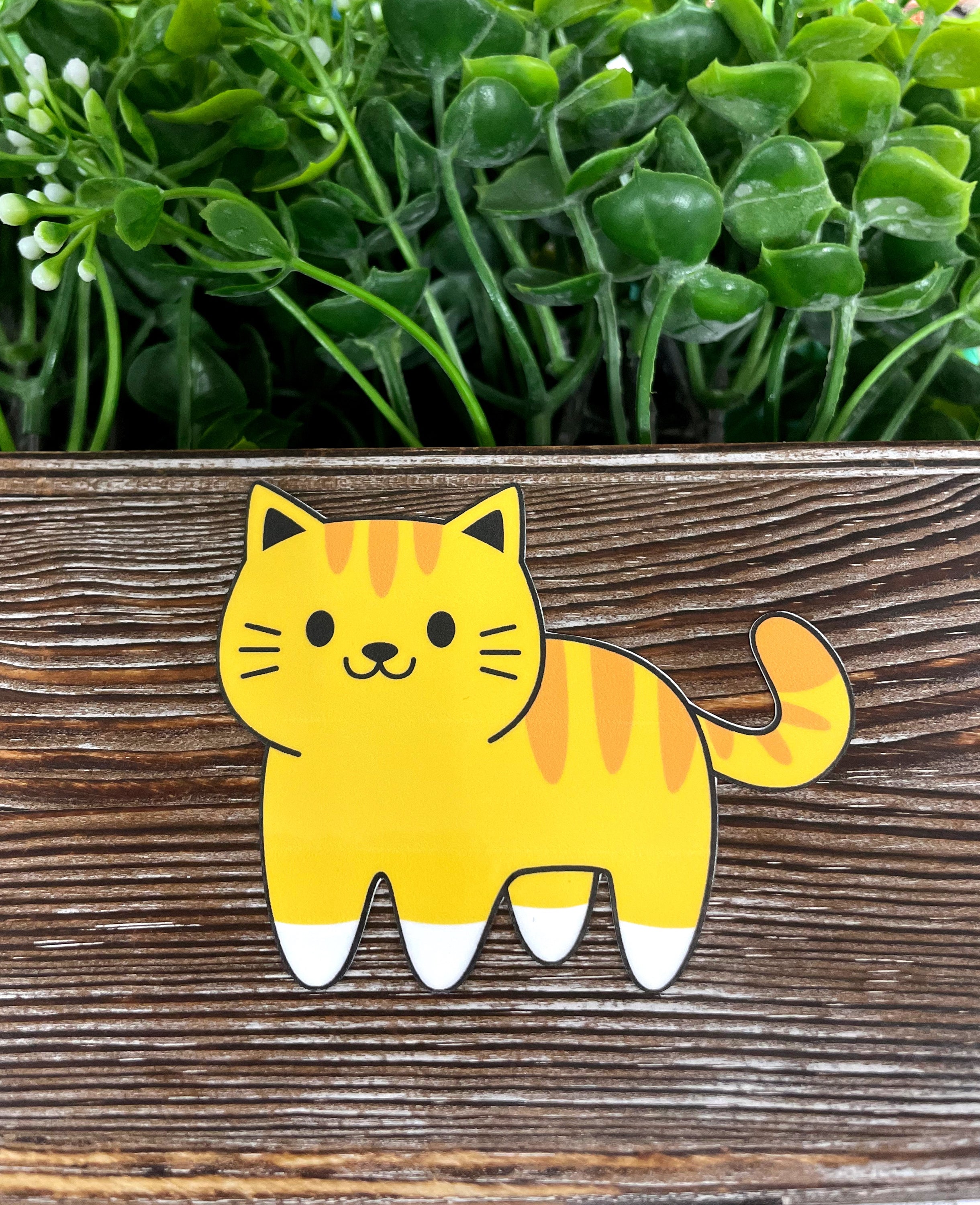 Orange striped cat sticker on a smooth surface, showcasing vibrant colors and die cut design.