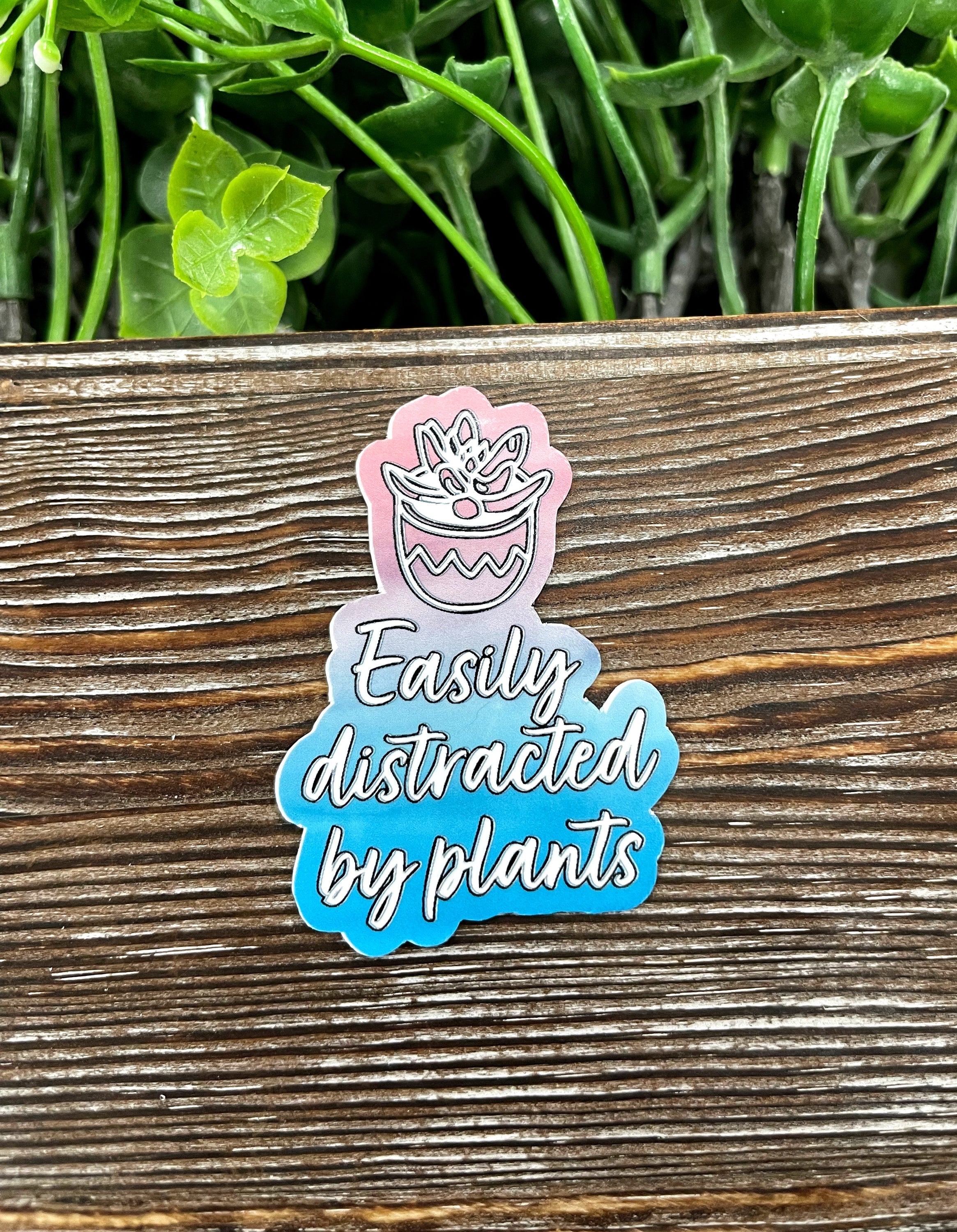 A vibrant die cut sticker featuring the phrase 'Easily Distracted by Plants', showcasing a playful design perfect for plant enthusiasts.