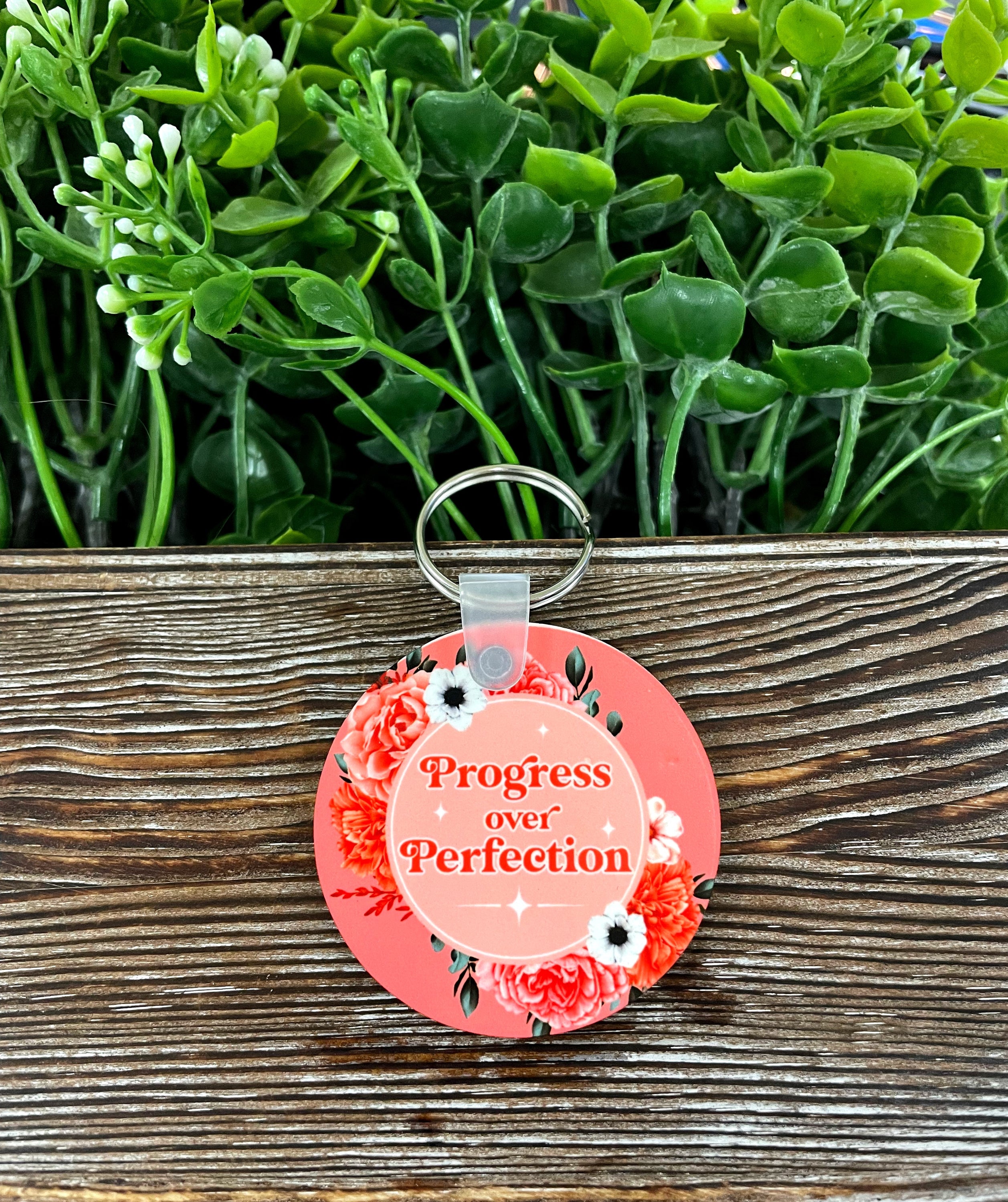 A lightweight MDF round keychain featuring the phrase 'Progress over Perfection' in a boho style design, perfect for personal expression.