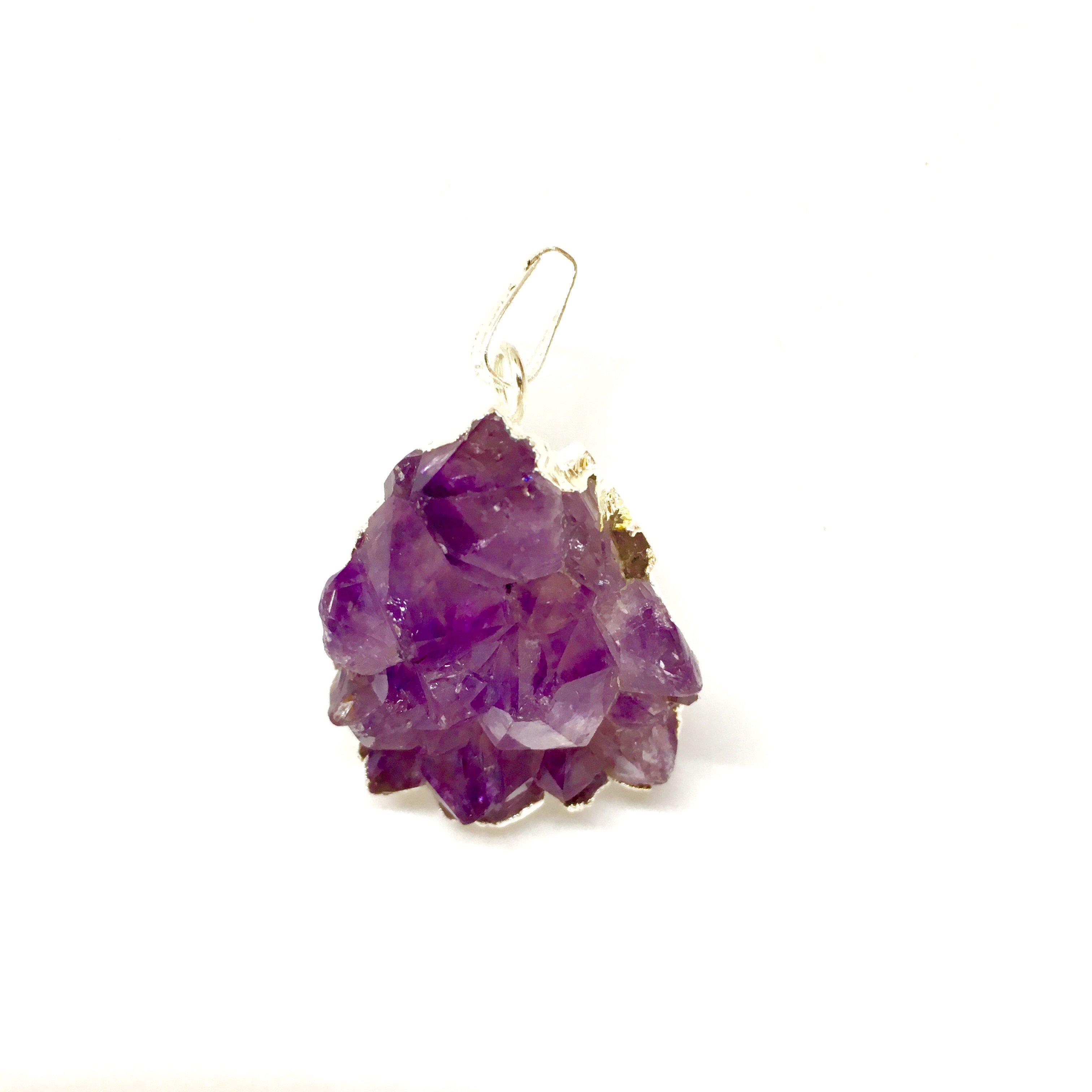 A stunning Purple Amethyst Cluster Pendant showcasing unique purple hues, gold metal plating, and a tan suede necklace.