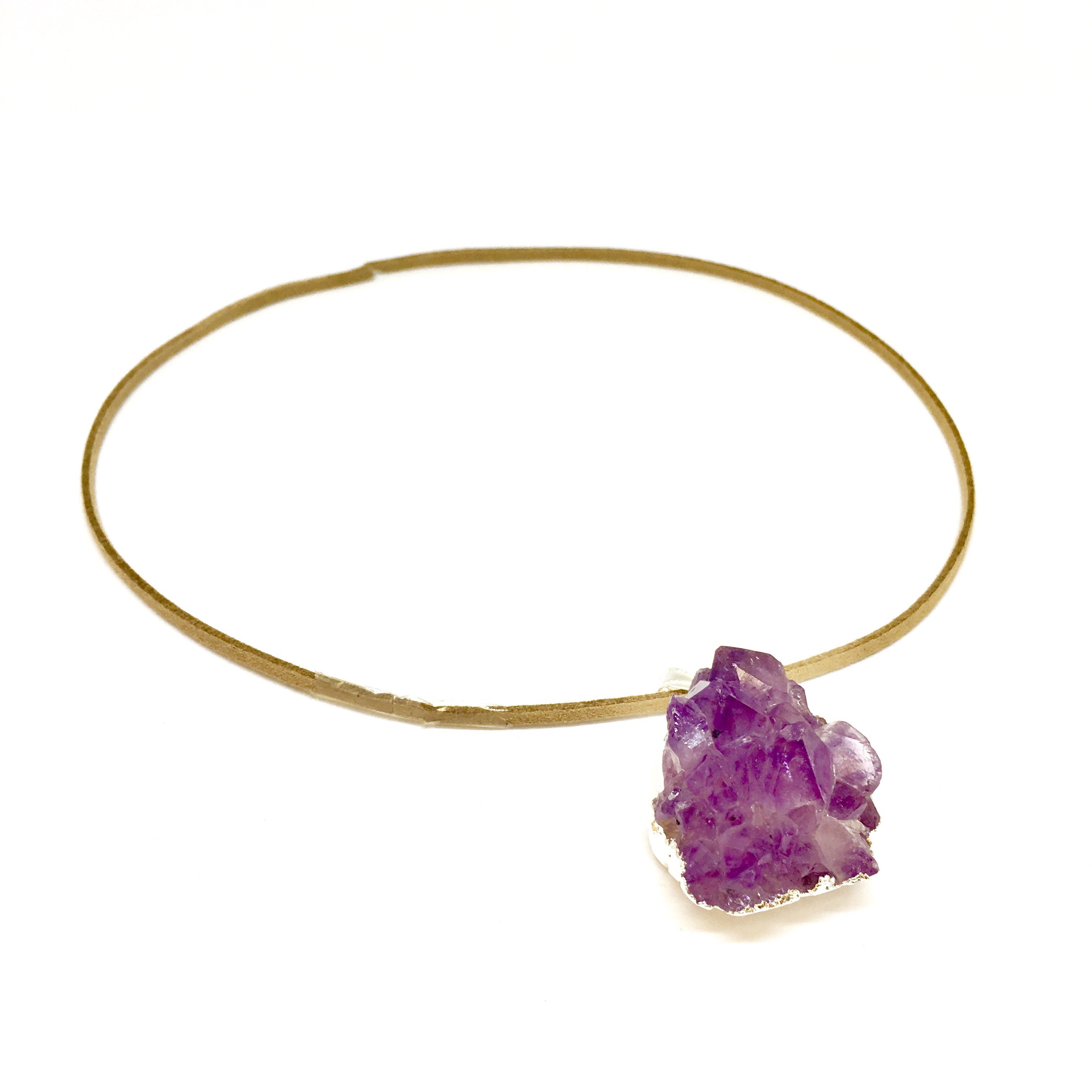 A stunning Purple Amethyst Cluster Pendant showcasing unique purple hues, gold metal plating, and a tan suede necklace.