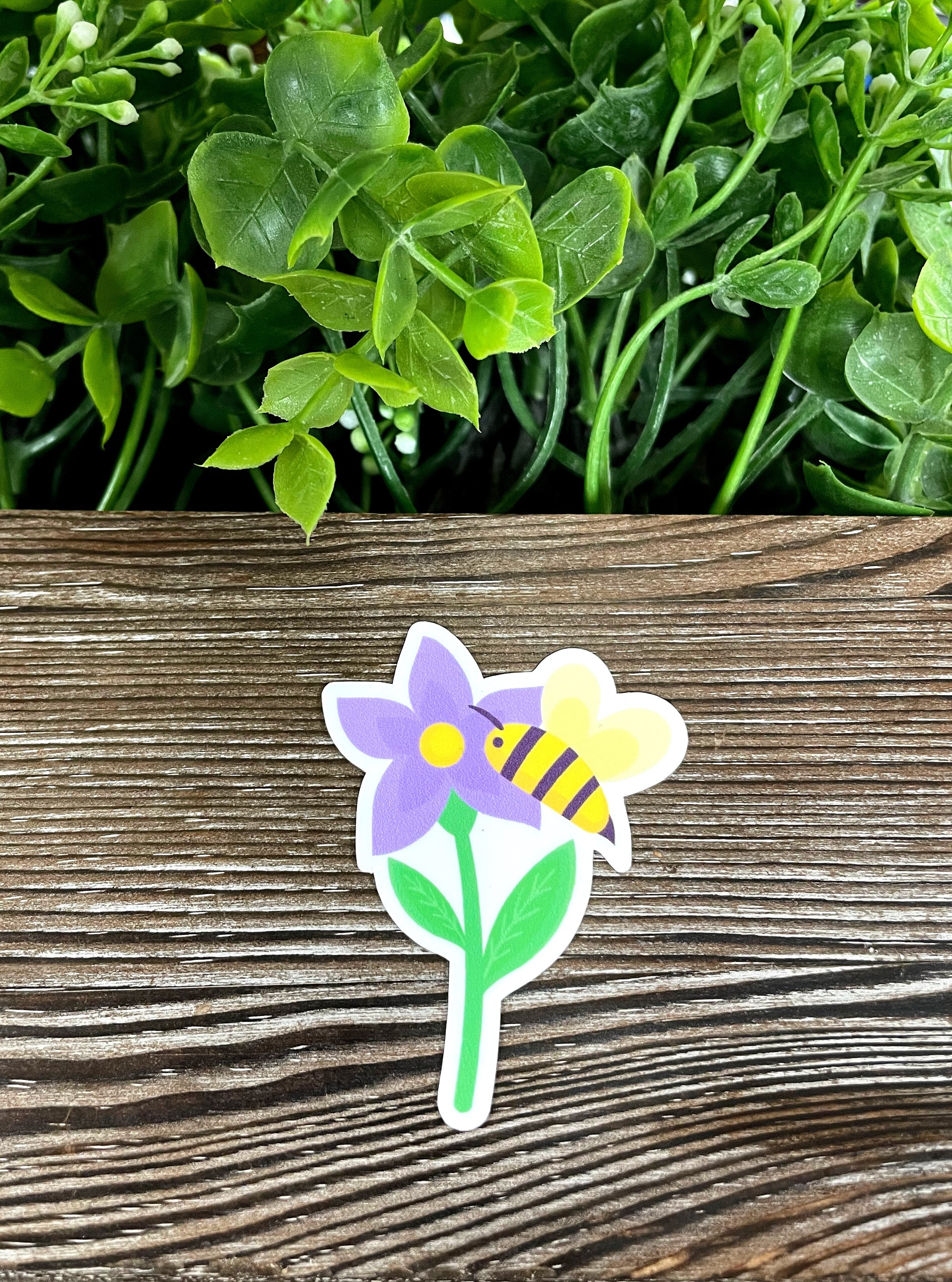 A vibrant die cut vinyl sticker featuring a purple flower and a bumblebee, showcasing a boho design perfect for personalizing items.