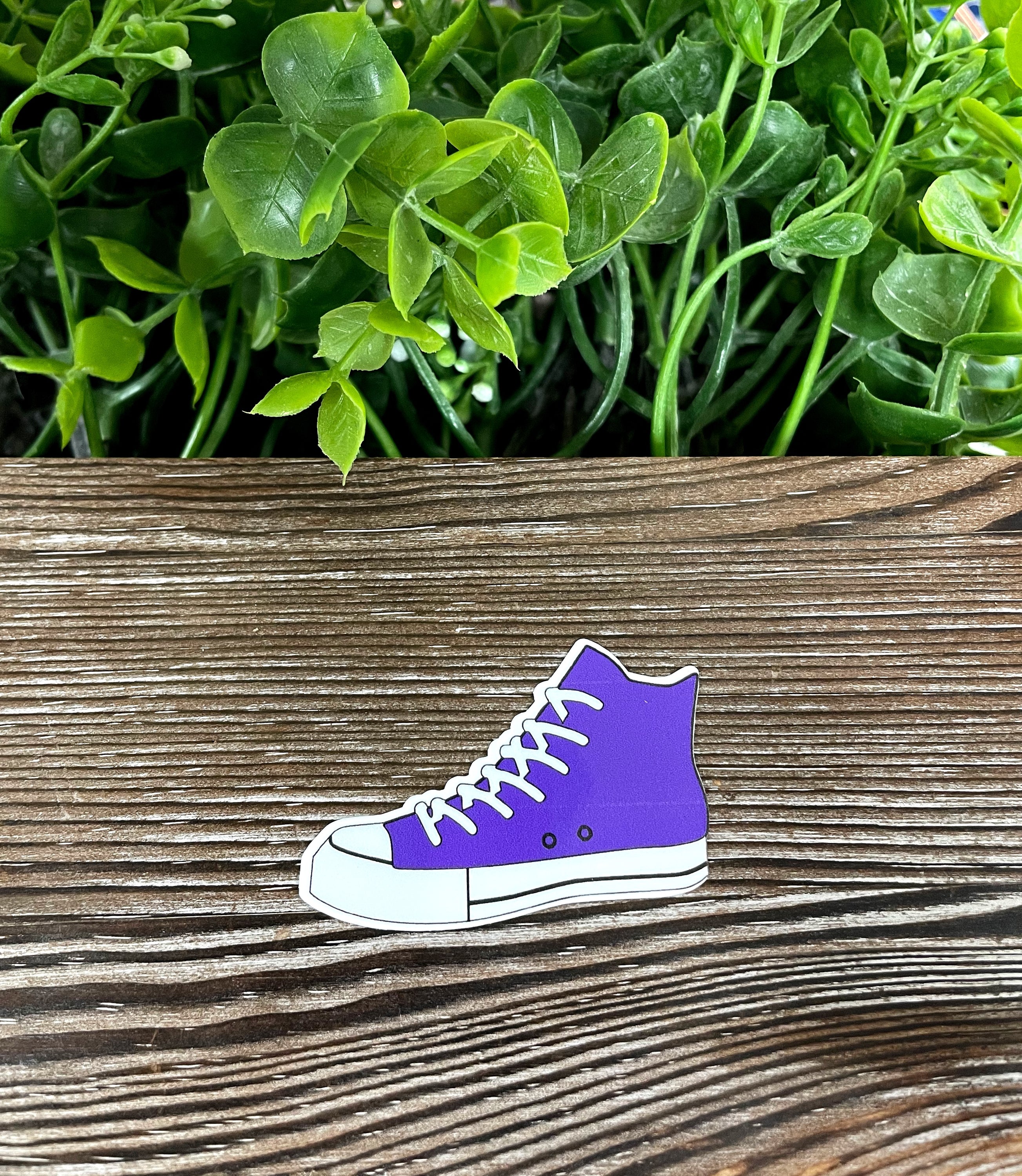 Purple high top shoes sticker on a smooth surface, showcasing vibrant colors and intricate design.