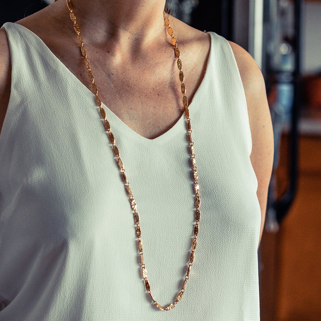 A stylish textured link long chain necklace with a high gloss finish, measuring 36 inches in length, featuring a lobster clasp and available in gold, silver, and rose gold.