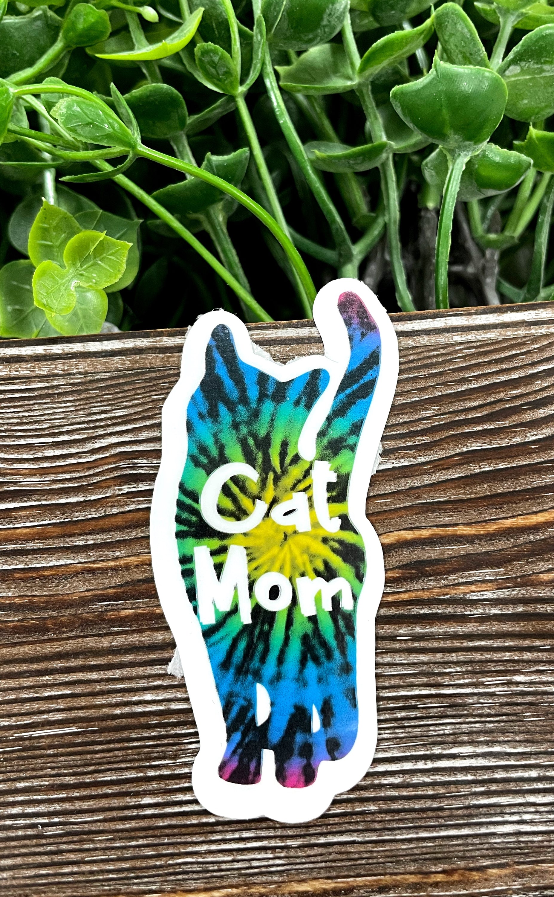 Colorful Tie Dye Cat Mom Die Cut Sticker on a smooth surface, showcasing vibrant colors and a playful design.