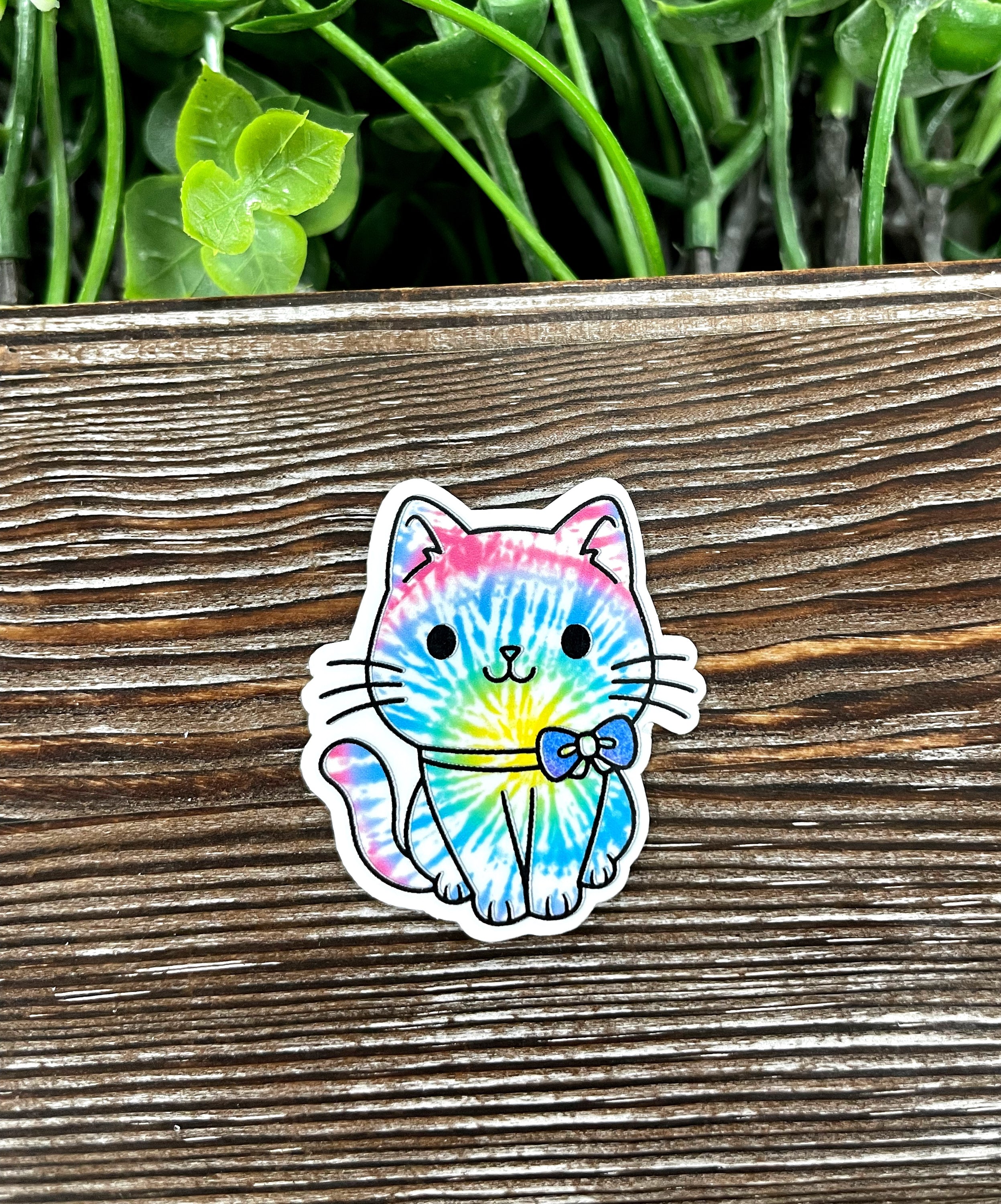 A vibrant tie dye cute cat die cut sticker featuring a colorful design, perfect for personalizing various smooth surfaces.