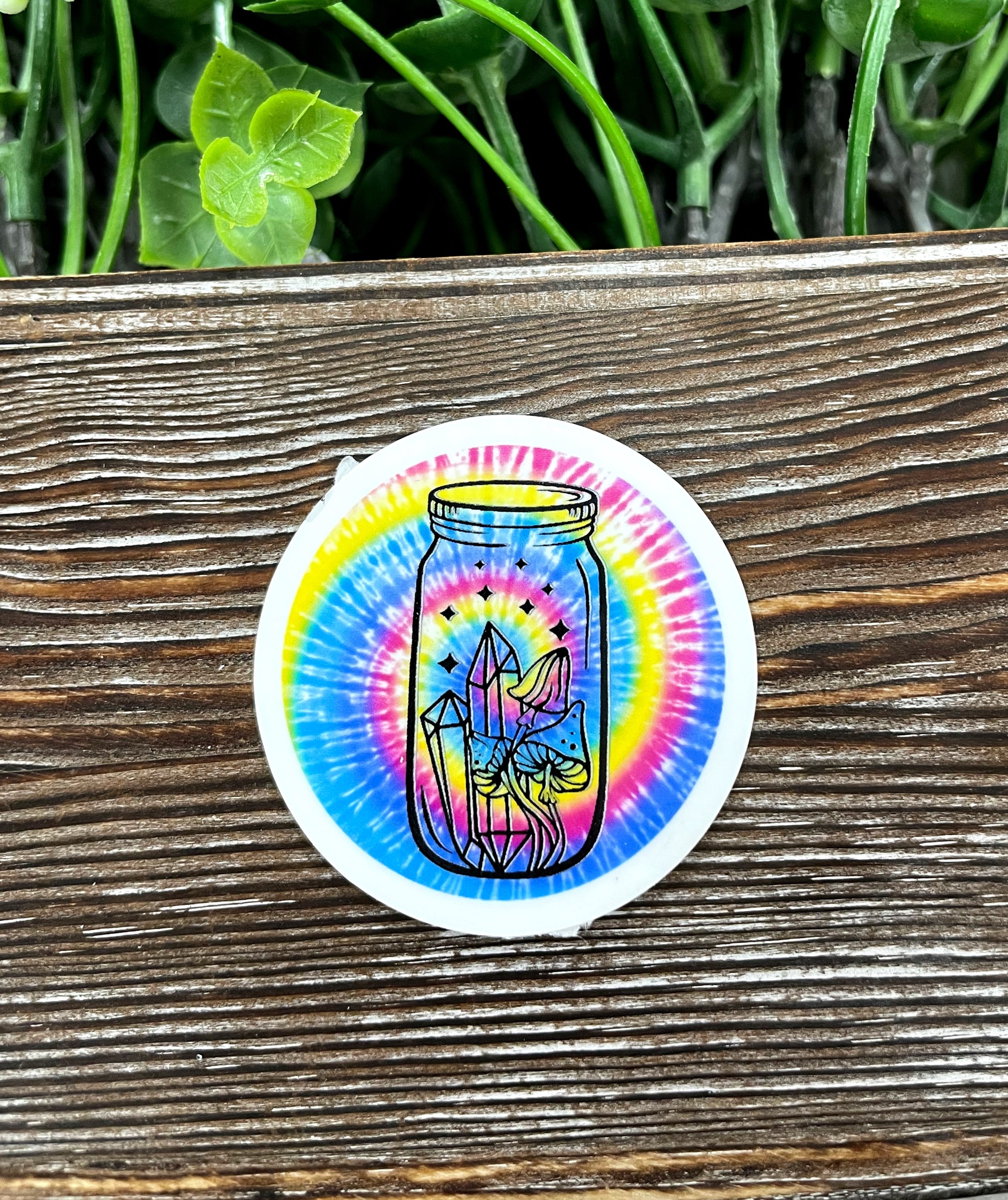 Colorful tie dye mason jar die cut sticker on a smooth surface, showcasing vibrant colors and intricate design.