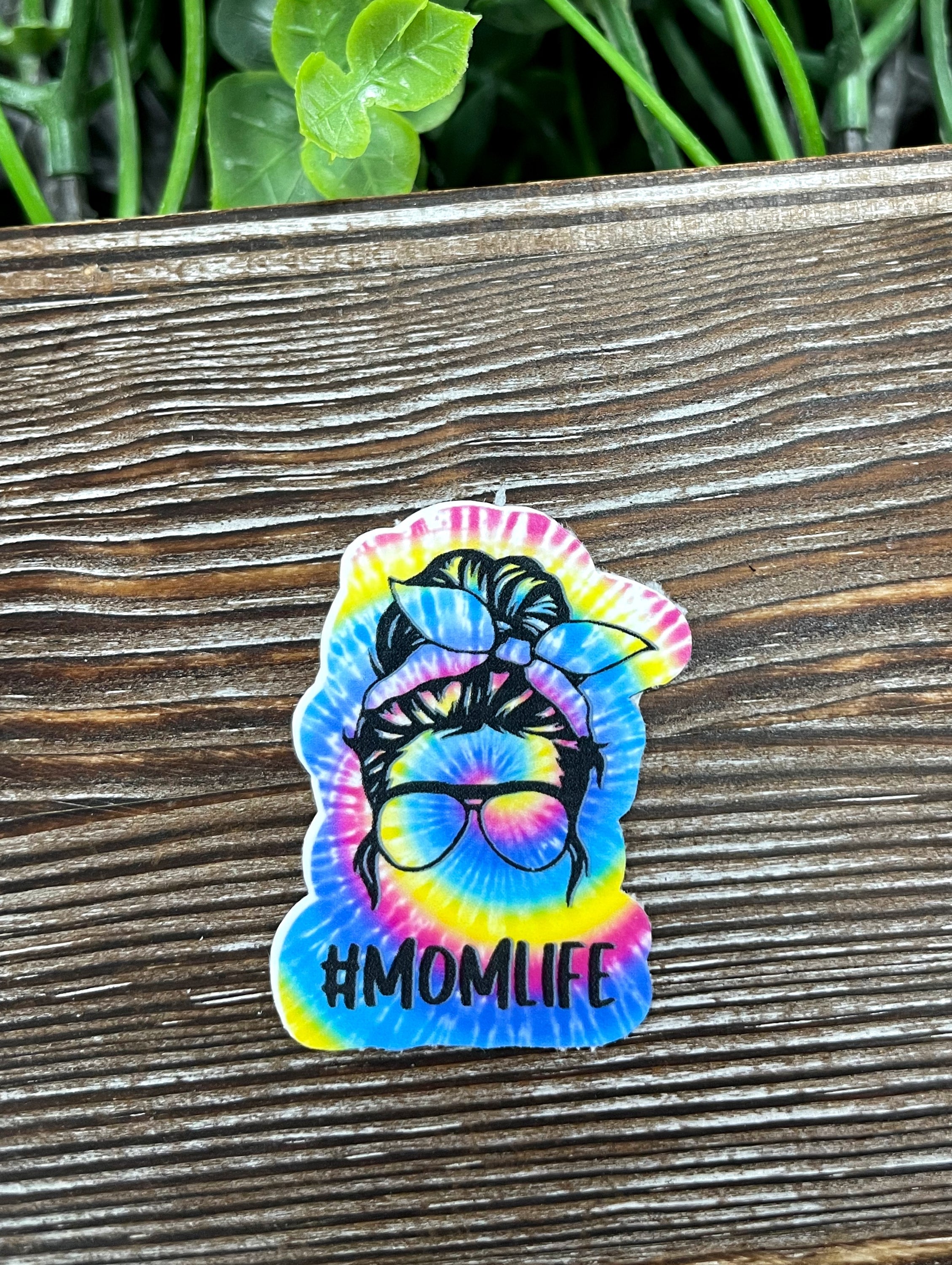 Colorful Tie Dye Mom Life Die Cut Sticker on a smooth surface, showcasing vibrant colors and a fun design.