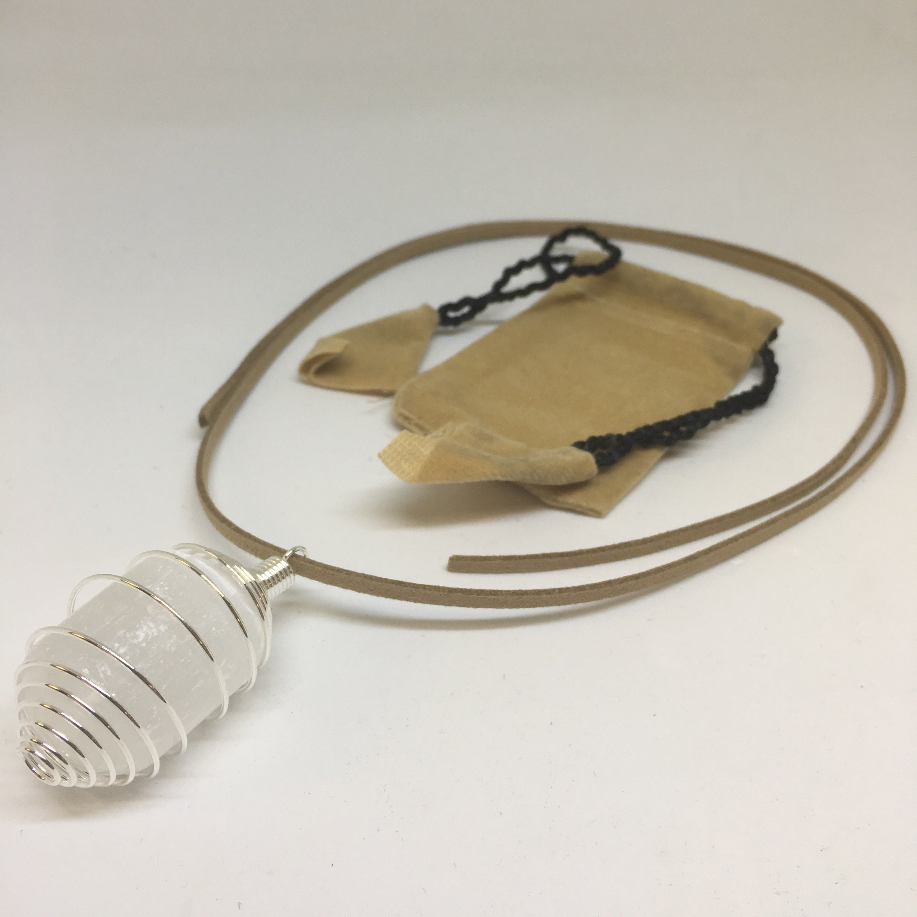 A collection of Tumbled Pendants featuring Opalite, Amethyst, Rose Quartz, Selenite, Angelite, and Hematite, elegantly displayed with a silver cage and tan suede necklace.