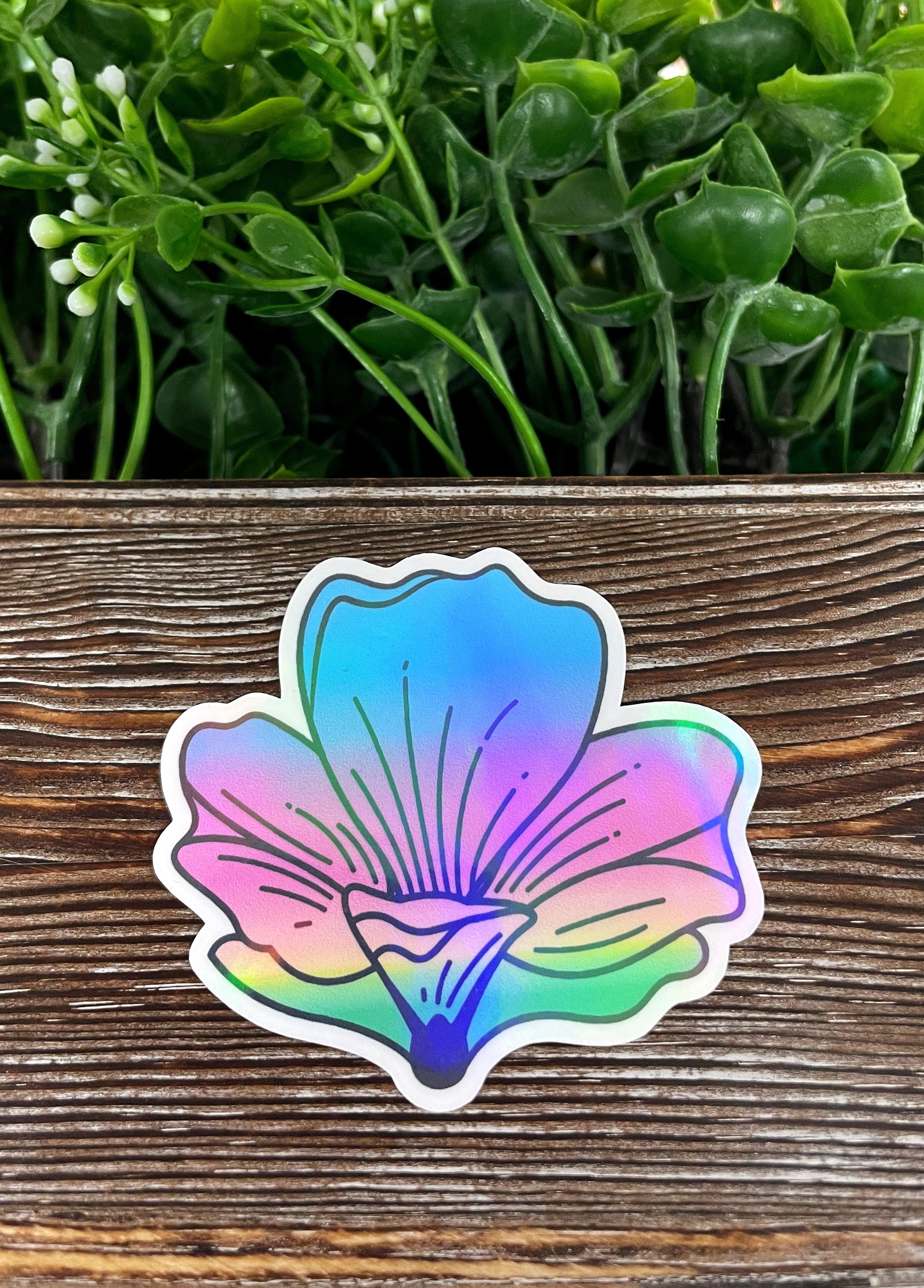 A vibrant watercolor flower die cut vinyl sticker on a smooth surface, showcasing its boho design and water-resistant laminate finish.