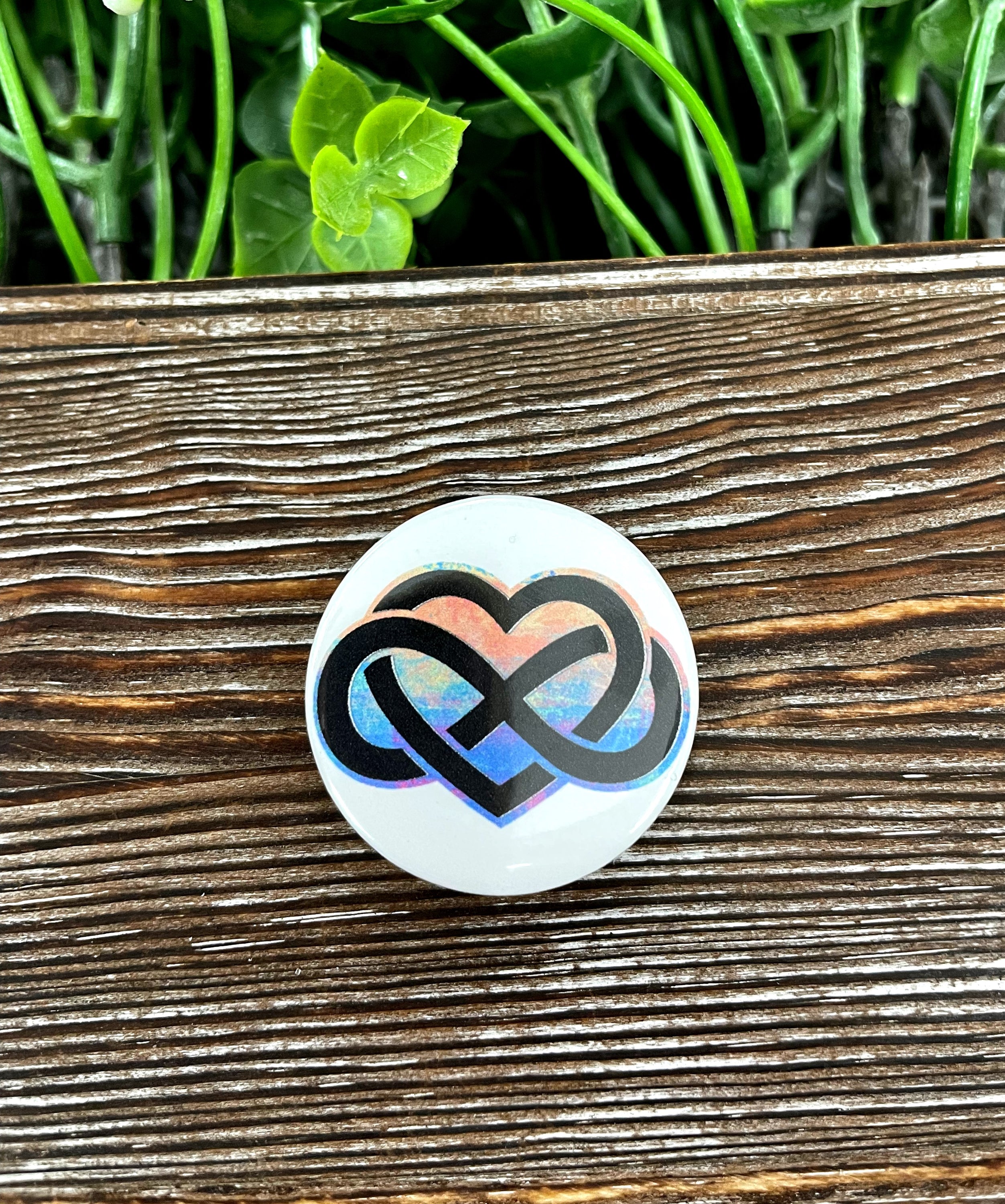 A colorful 1.25-inch button featuring a watercolor infinity heart design, perfect for personalizing bags and accessories.