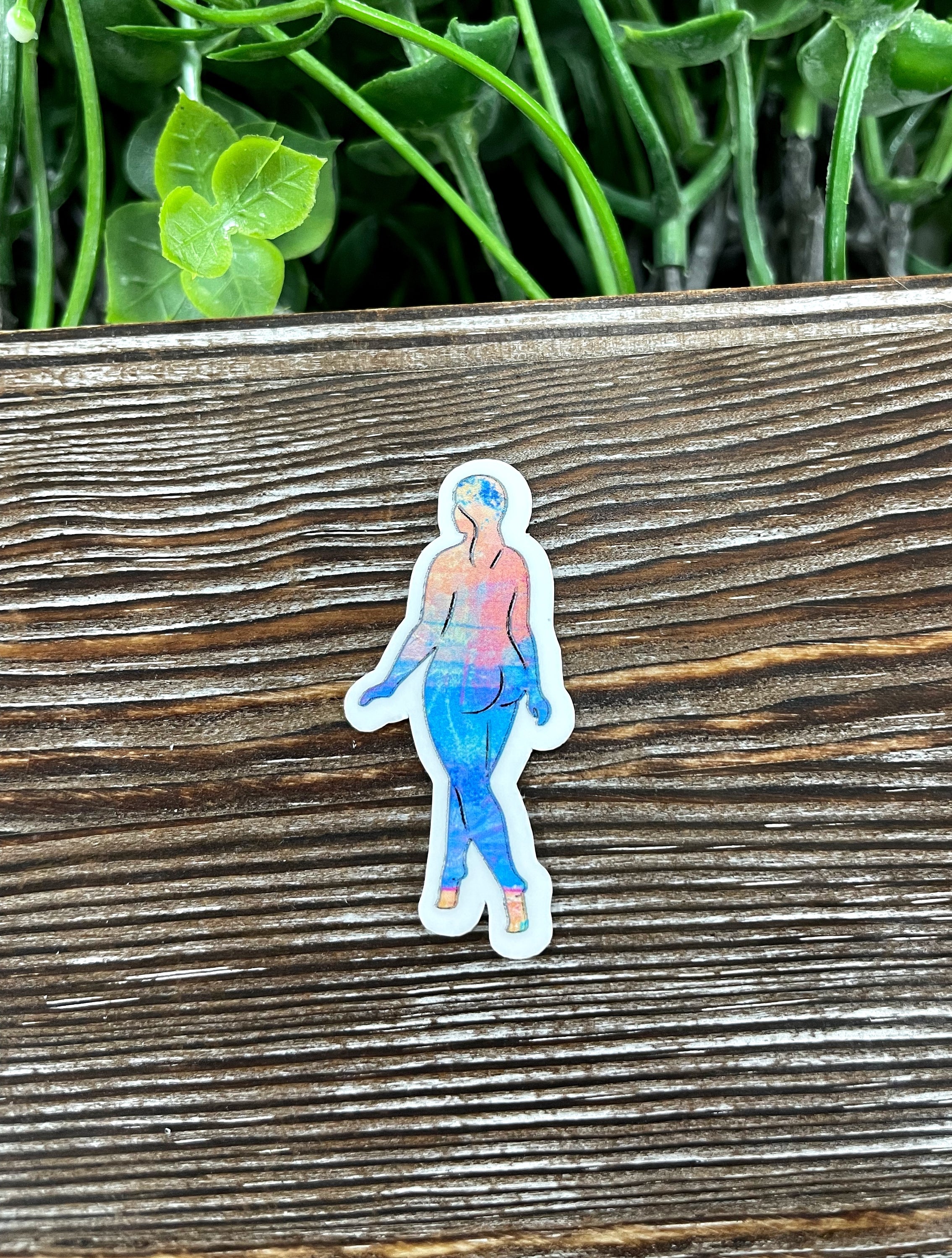 A vibrant watercolor woman silhouette die cut sticker on a smooth surface, showcasing artistic design and quality finish.