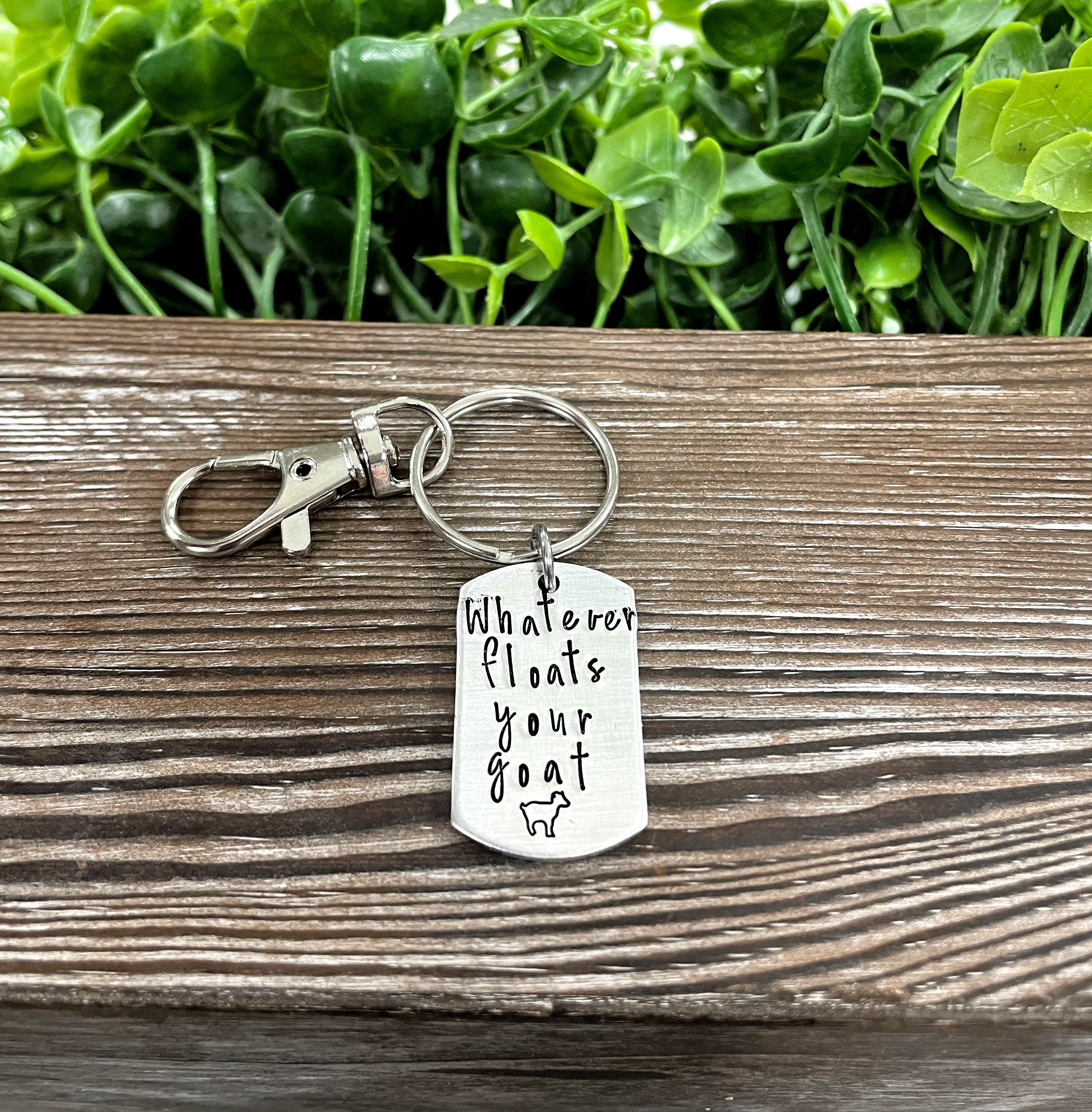 Hand-stamped key chain featuring the phrase 'Whatever floats your goat' with a fun animal theme, showcasing unique craftsmanship.