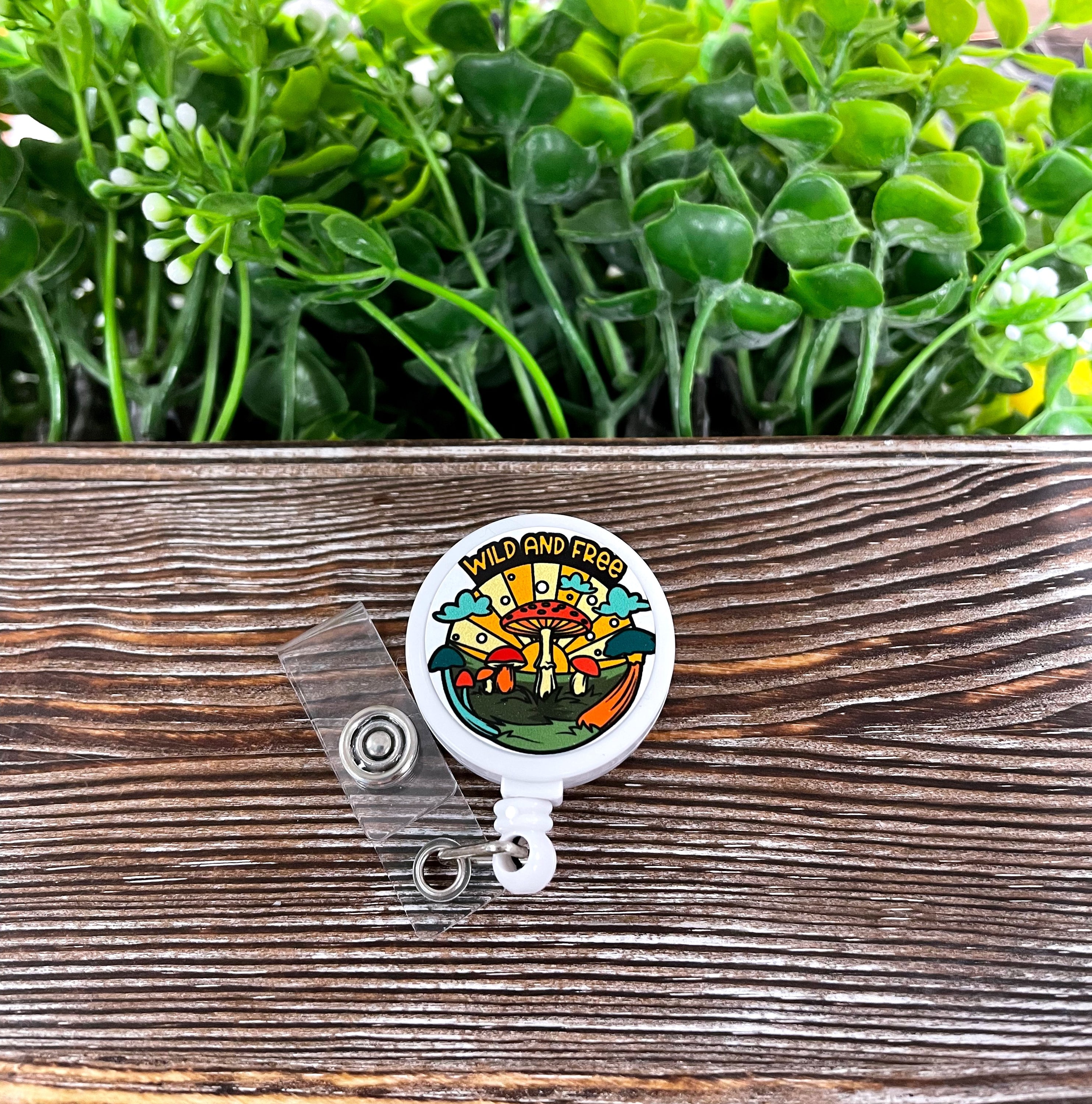 Wild and Free Mushrooms retractable badge reel featuring a colorful mushroom design on a metal blank attached to a plastic reel.