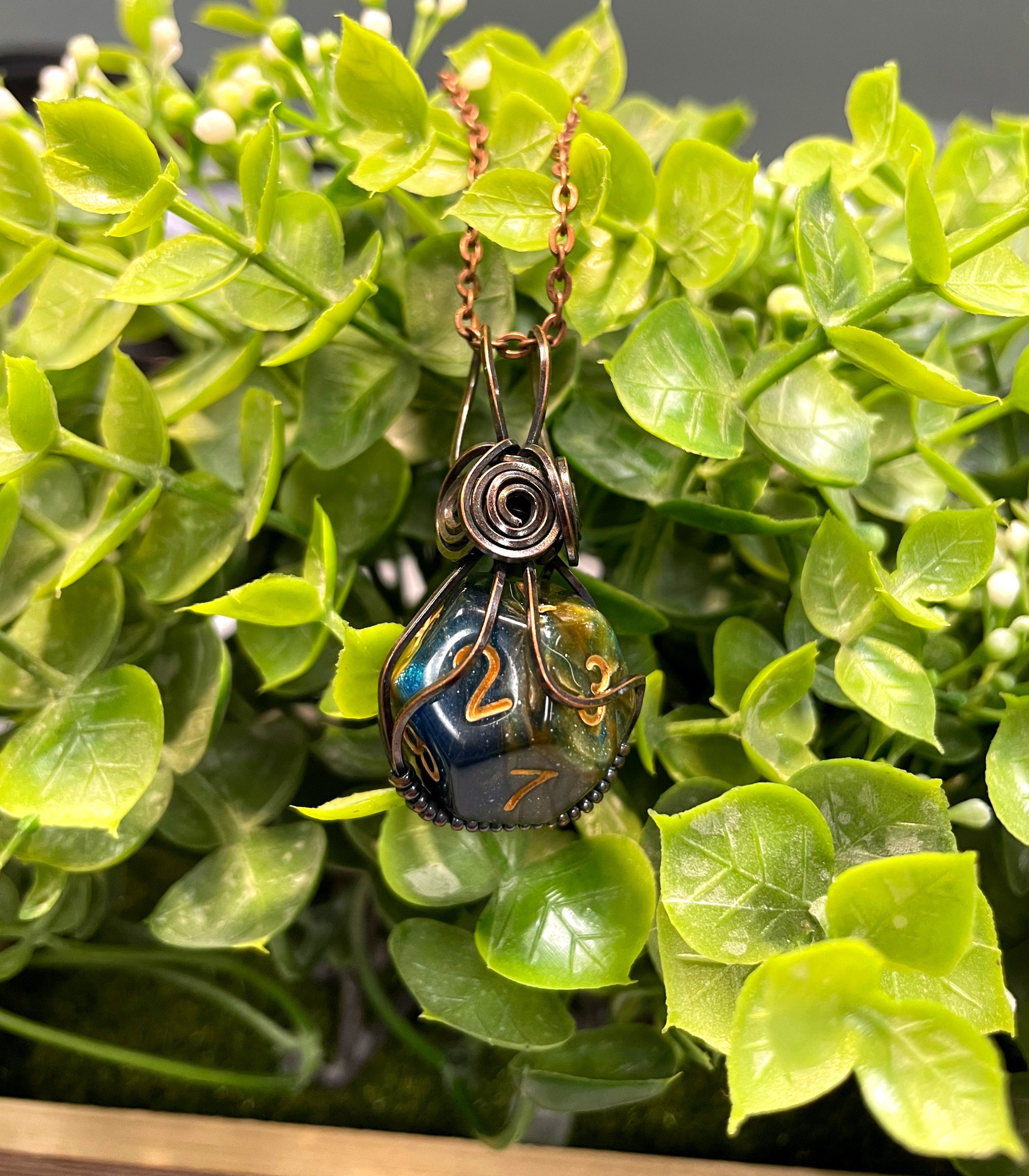 Wire Wrapped D12 Dice Pendant featuring a blue D10 dice wrapped in oxidized copper wire on a suede leather cord.