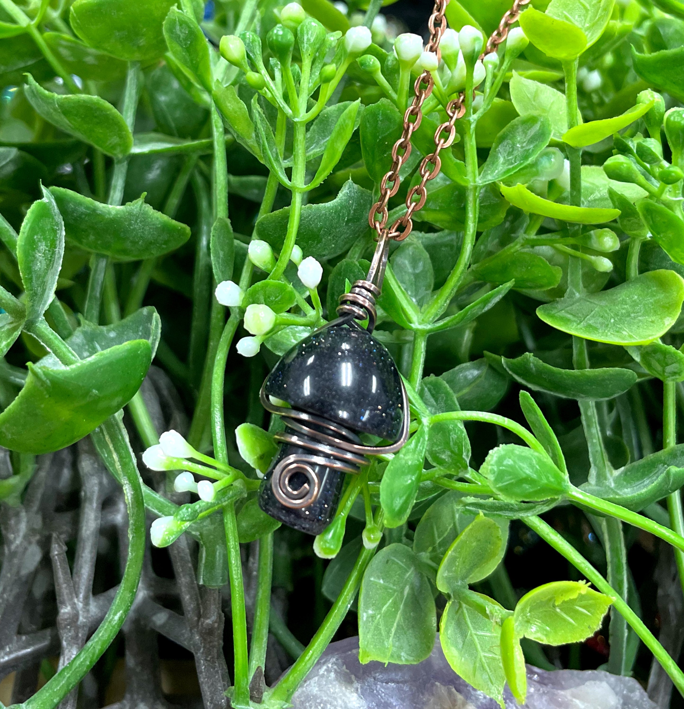 Wire Wrapped Mushroom Gemstone Pendant featuring a charming mushroom-shaped gemstone wrapped in oxidized copper wire on a 21-inch cord.