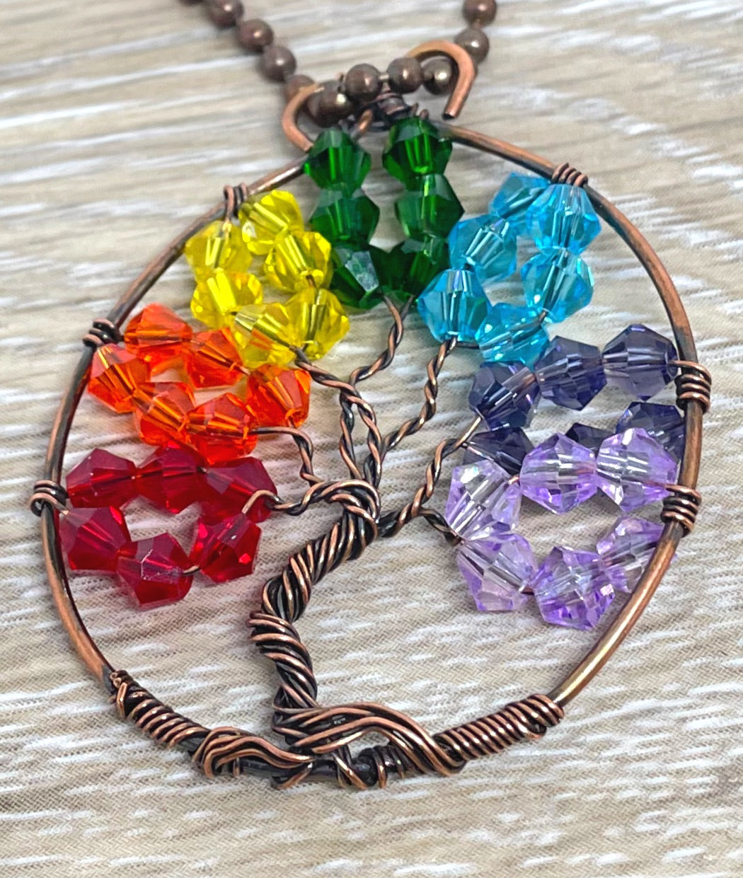 Wire Wrapped Rainbow Tree of Life Pendant featuring colorful glass crystals and oxidized copper wire on an 18-inch ball chain.