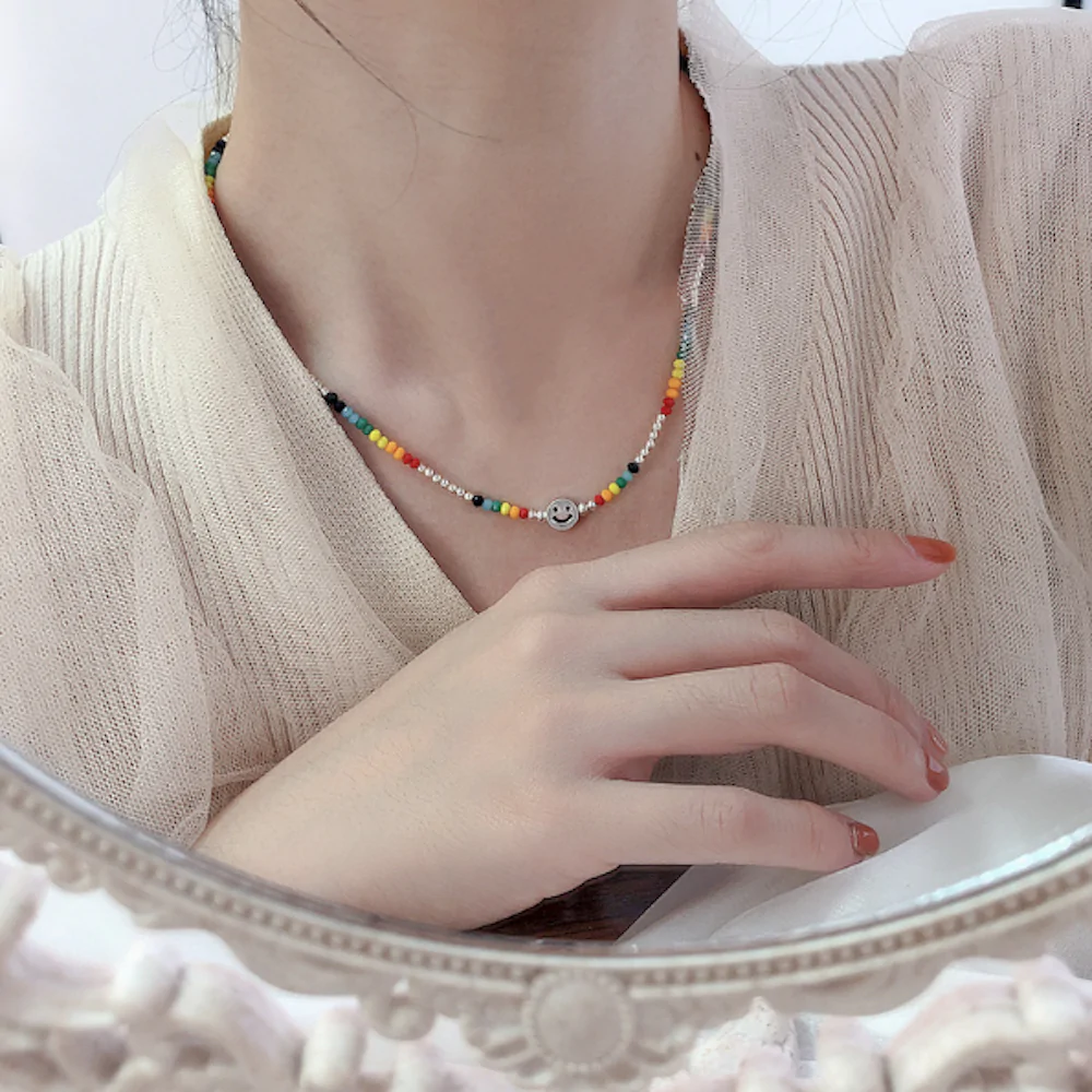 A vibrant women's beaded necklace featuring a happy face design, perfect for summer fashion.