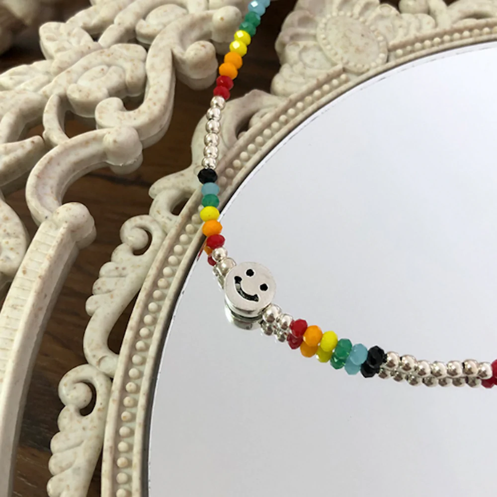 A vibrant women's beaded necklace featuring a happy face design, perfect for summer fashion.