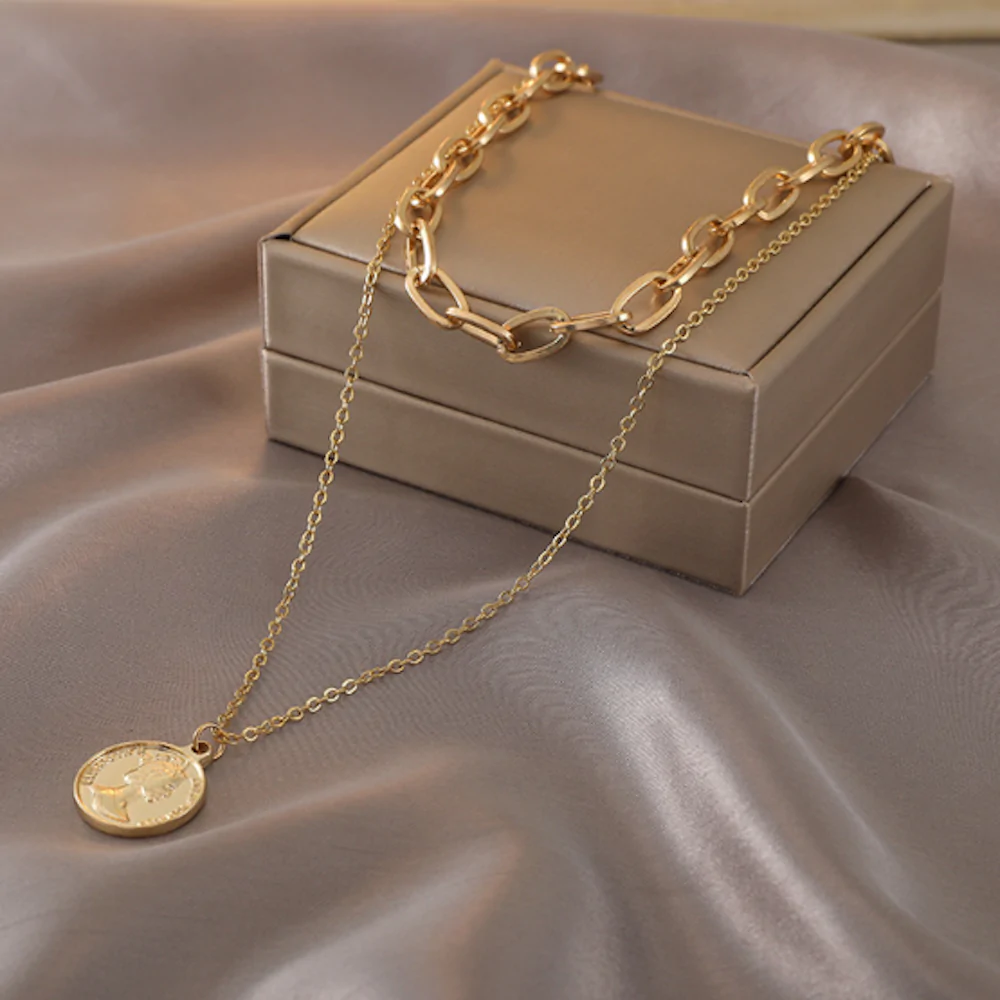 Womens Layered Look Choker Necklace featuring a gold-plated finish and a unique coin pendant, elegantly displayed on a soft background.