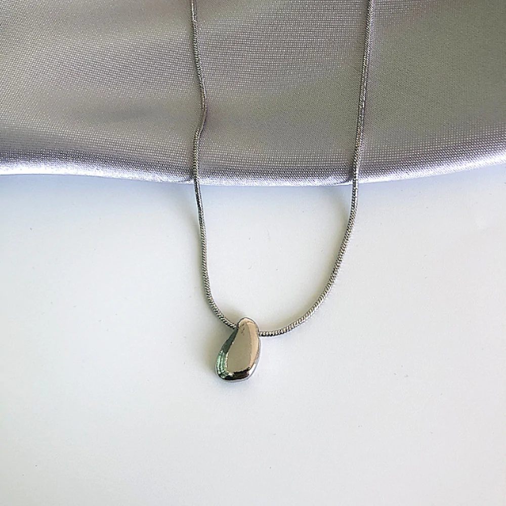 Elegant Women's Necklace featuring a unique Bean Pendant in gold and silver plating, showcasing its stylish design and quality craftsmanship.