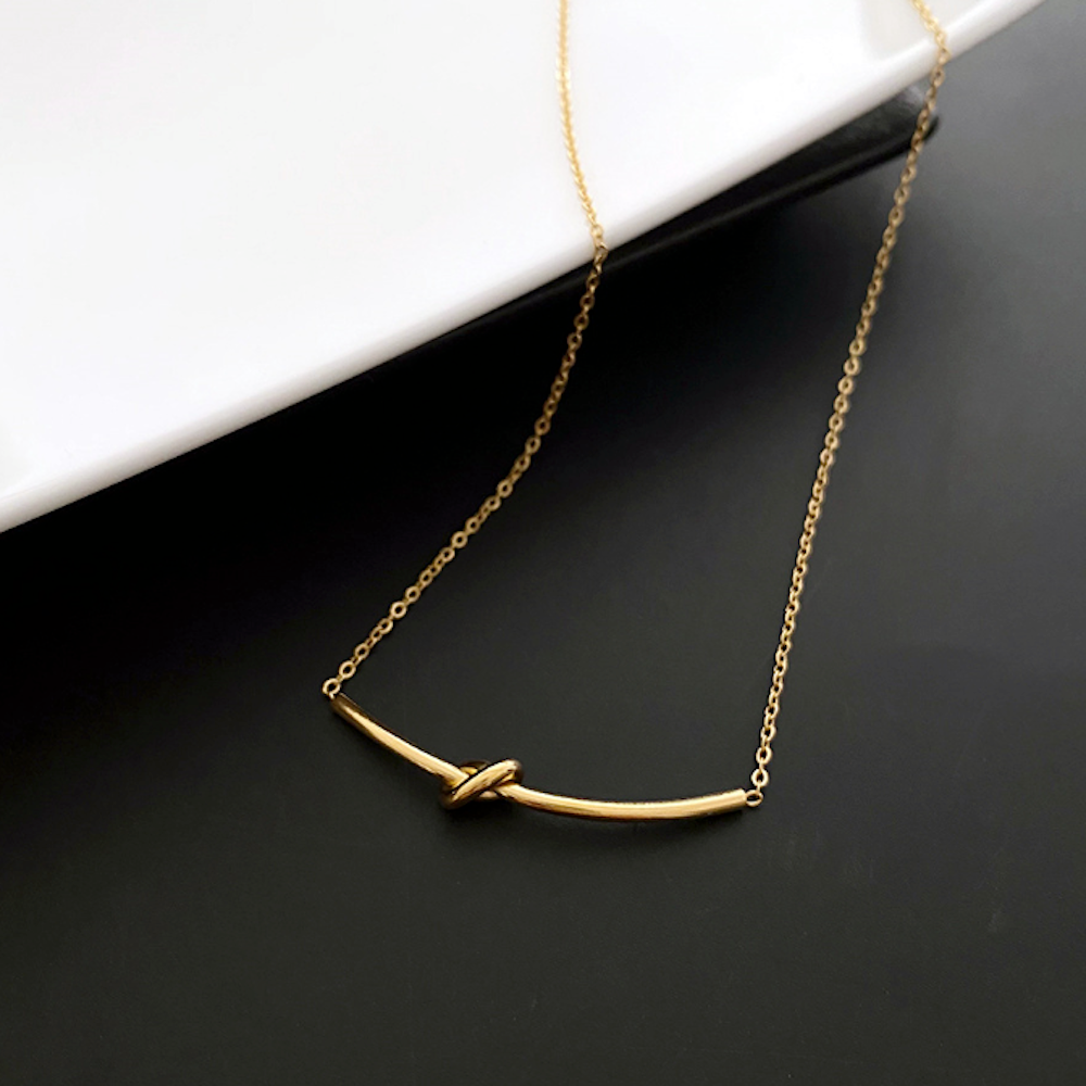 Womens Tie The Knot Necklace featuring a gold plated alloy design, adjustable length, and a simple yet elegant knot motif.