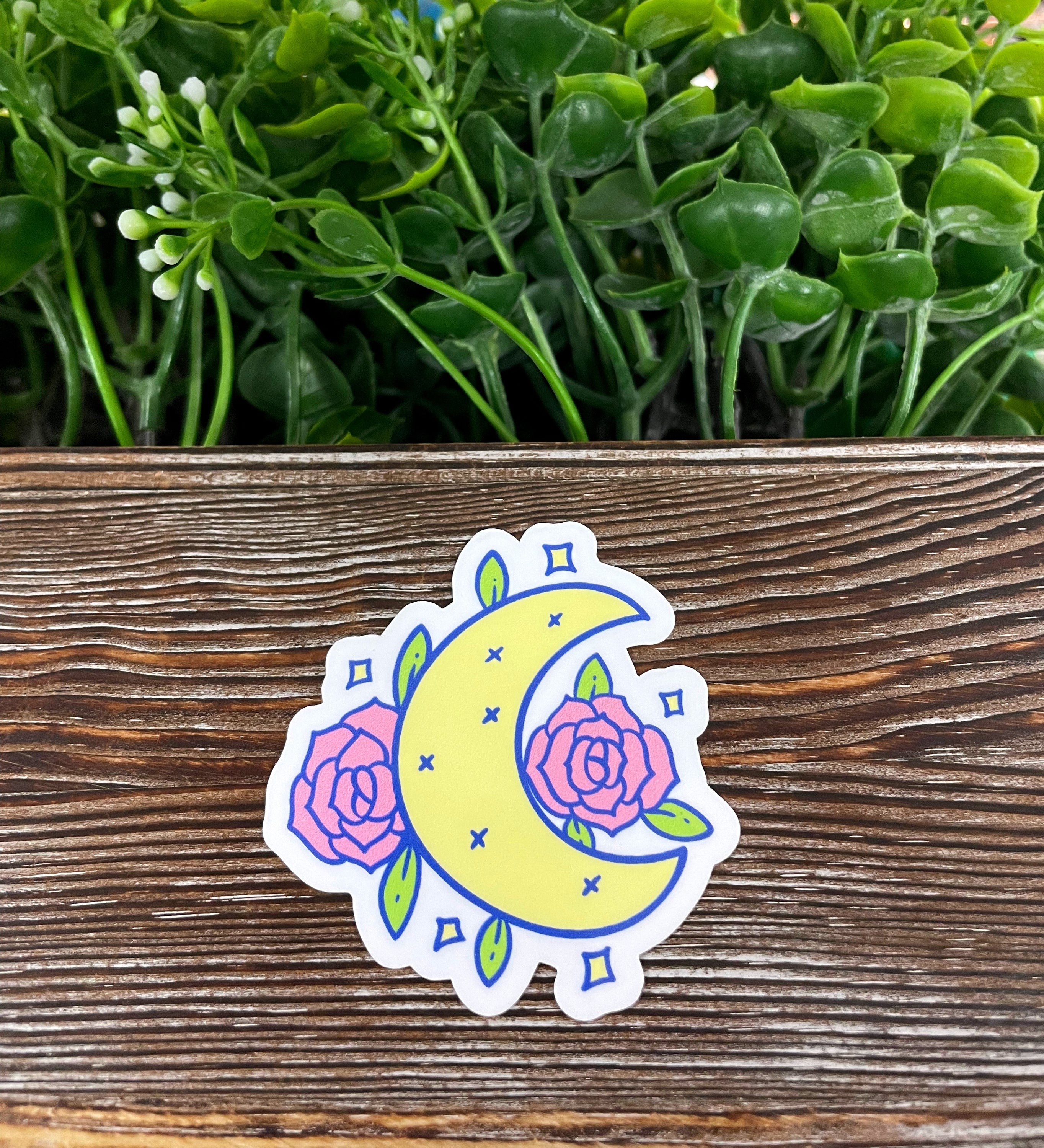 A vibrant yellow crescent moon sticker with pink flowers, showcasing a die cut design perfect for personalizing various smooth surfaces.