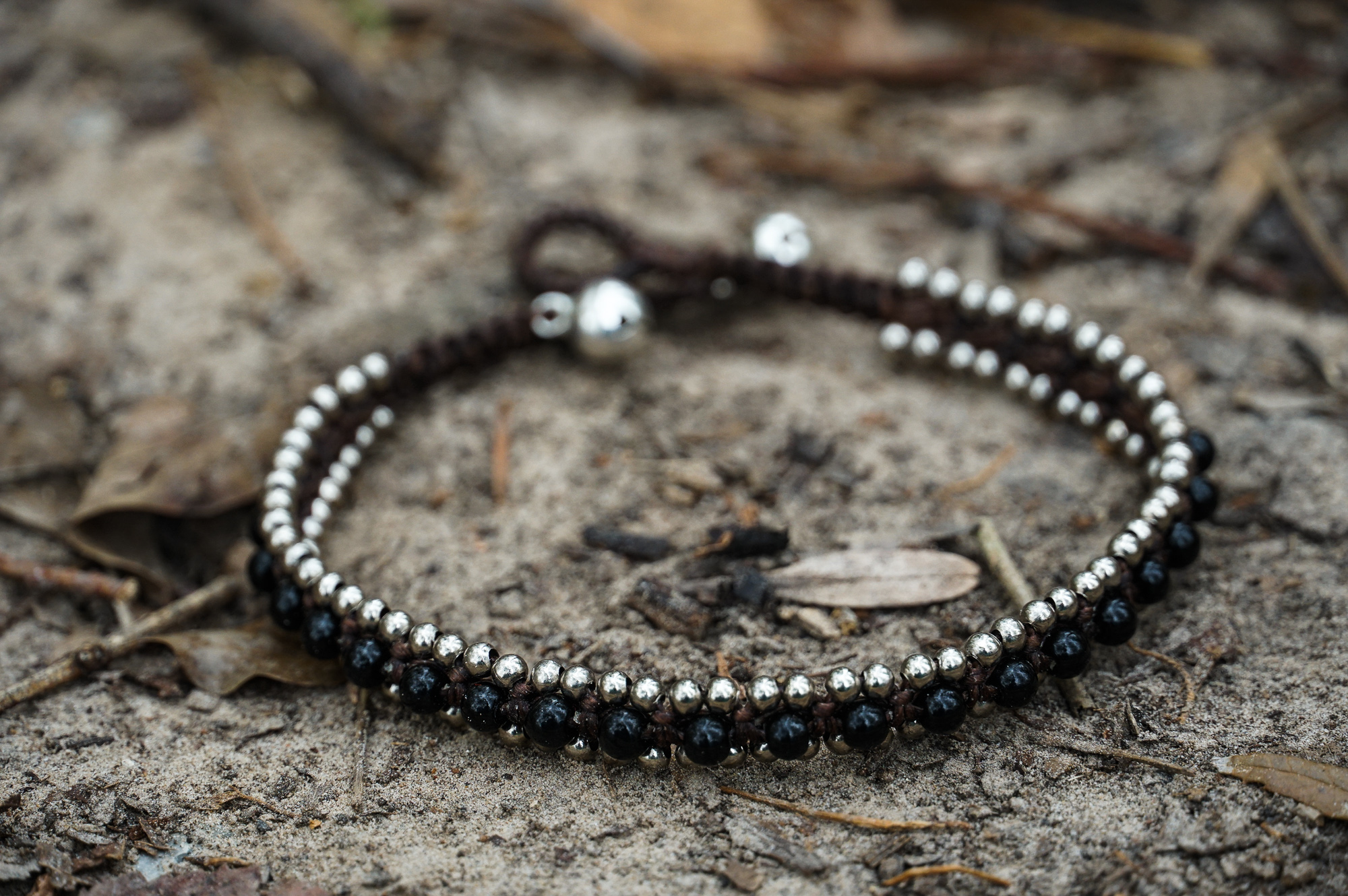 Black Band Boho Silver Anklet featuring silver bells and cotton chords, handcrafted by Thai artisans.