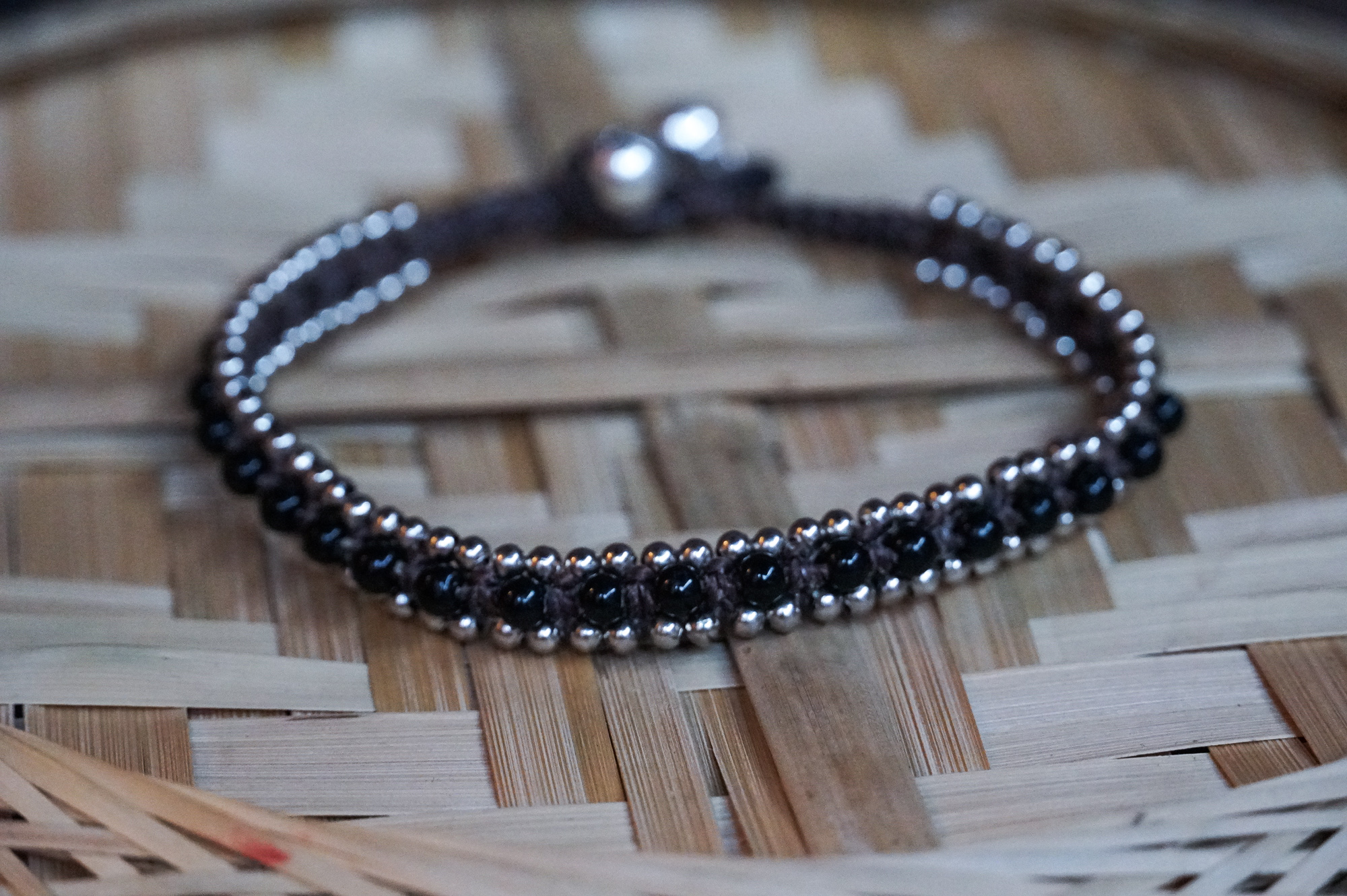 Black Band Boho Silver Anklet featuring silver bells and cotton chords, handcrafted by Thai artisans.