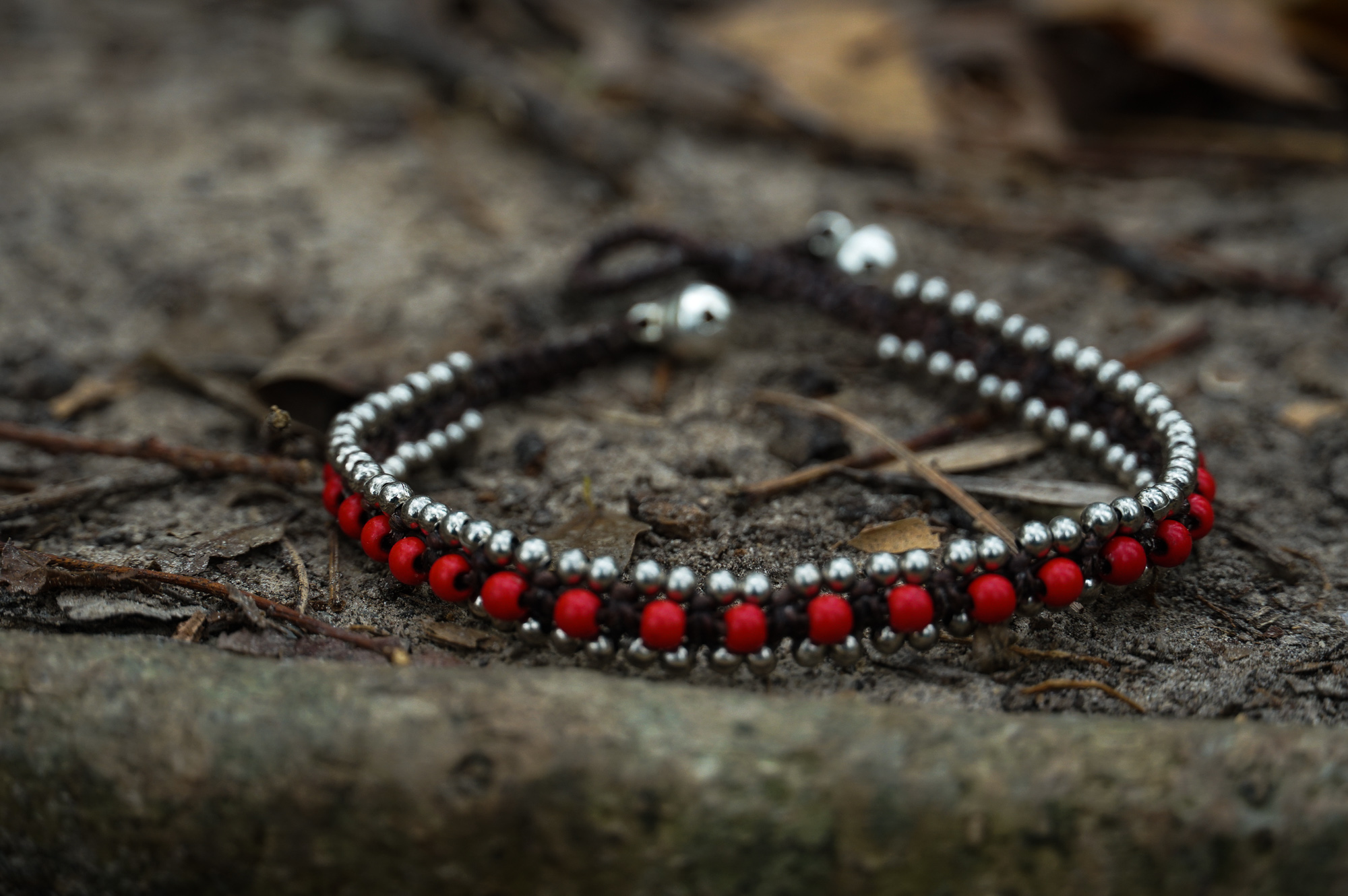 Red Band Boho Silver Anklet featuring silver bells and cotton chords, handcrafted by Thai artisans, perfect for bohemian style.