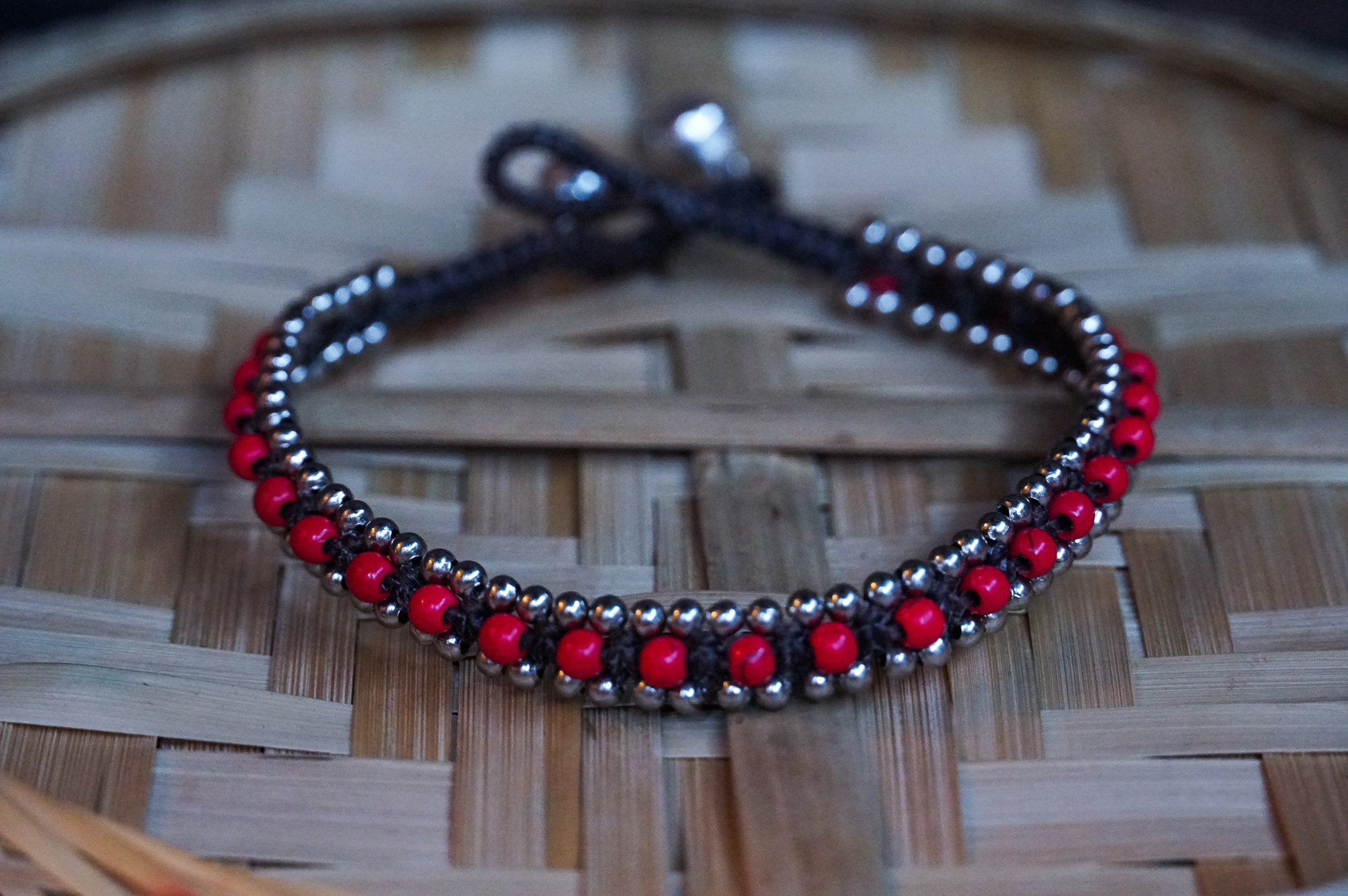 Red Band Boho Silver Anklet featuring silver bells and cotton chords, handcrafted by Thai artisans, perfect for bohemian style.