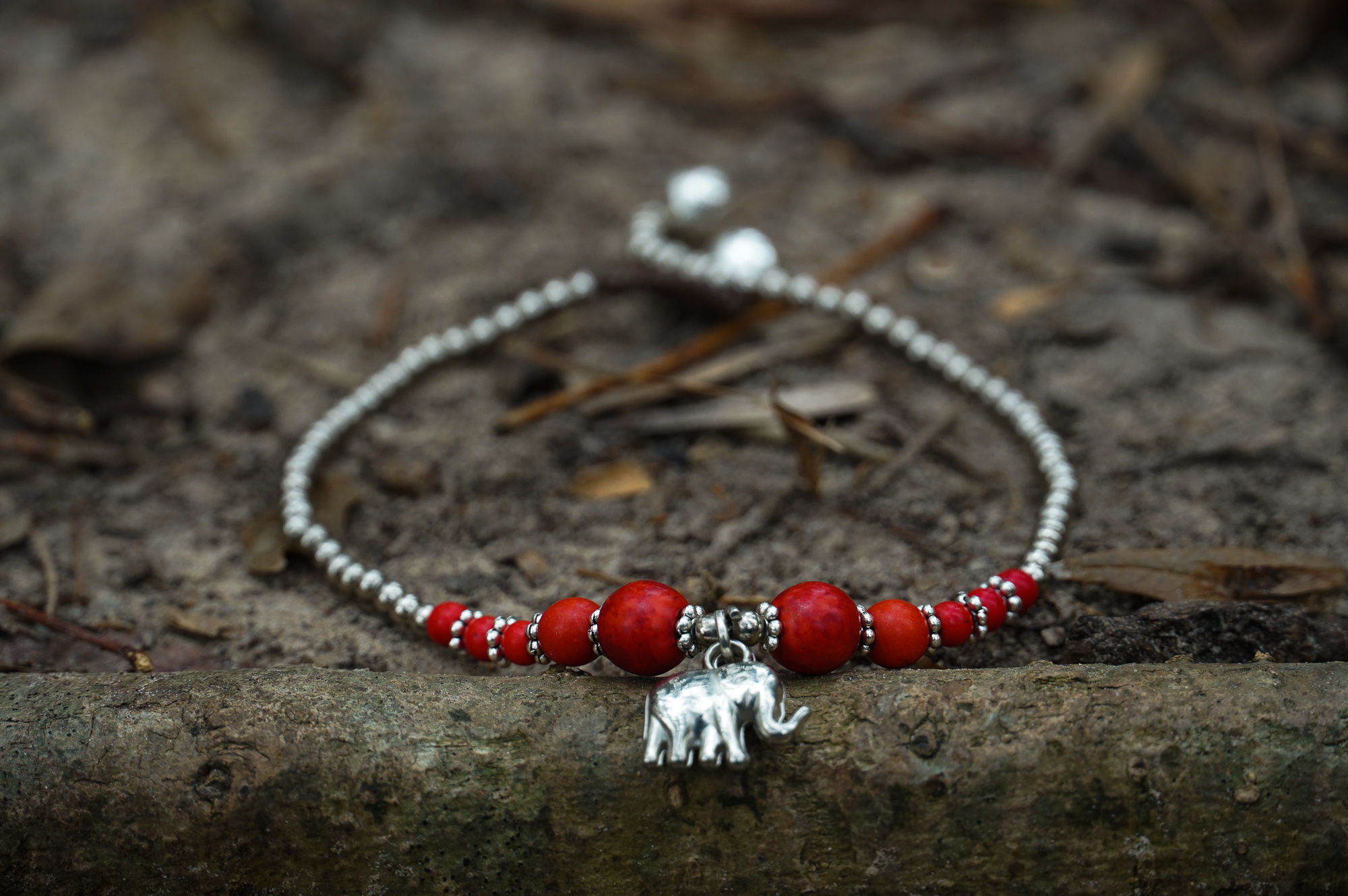 A beautifully handcrafted Red Elephant Pendant Boho Silver Anklet featuring silver bells and pressed cotton chords, perfect for bohemian style lovers.