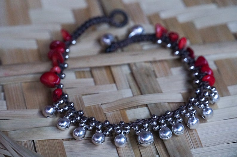 A beautifully handcrafted Red Silver Bell Stone Boho Anklet featuring silver bells, pressed cotton chords, and natural stones, perfect for bohemian style.