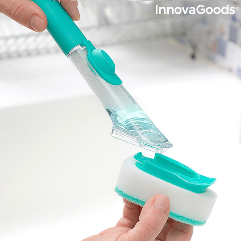 Hand holding dish scrubber with soap.