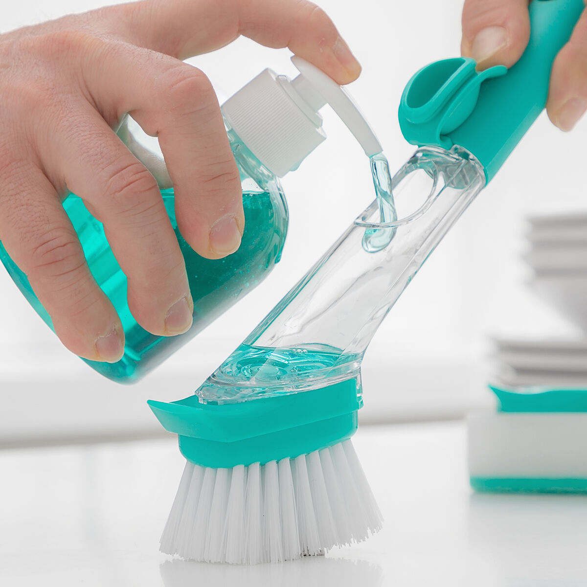 Filling dish brush with soap.