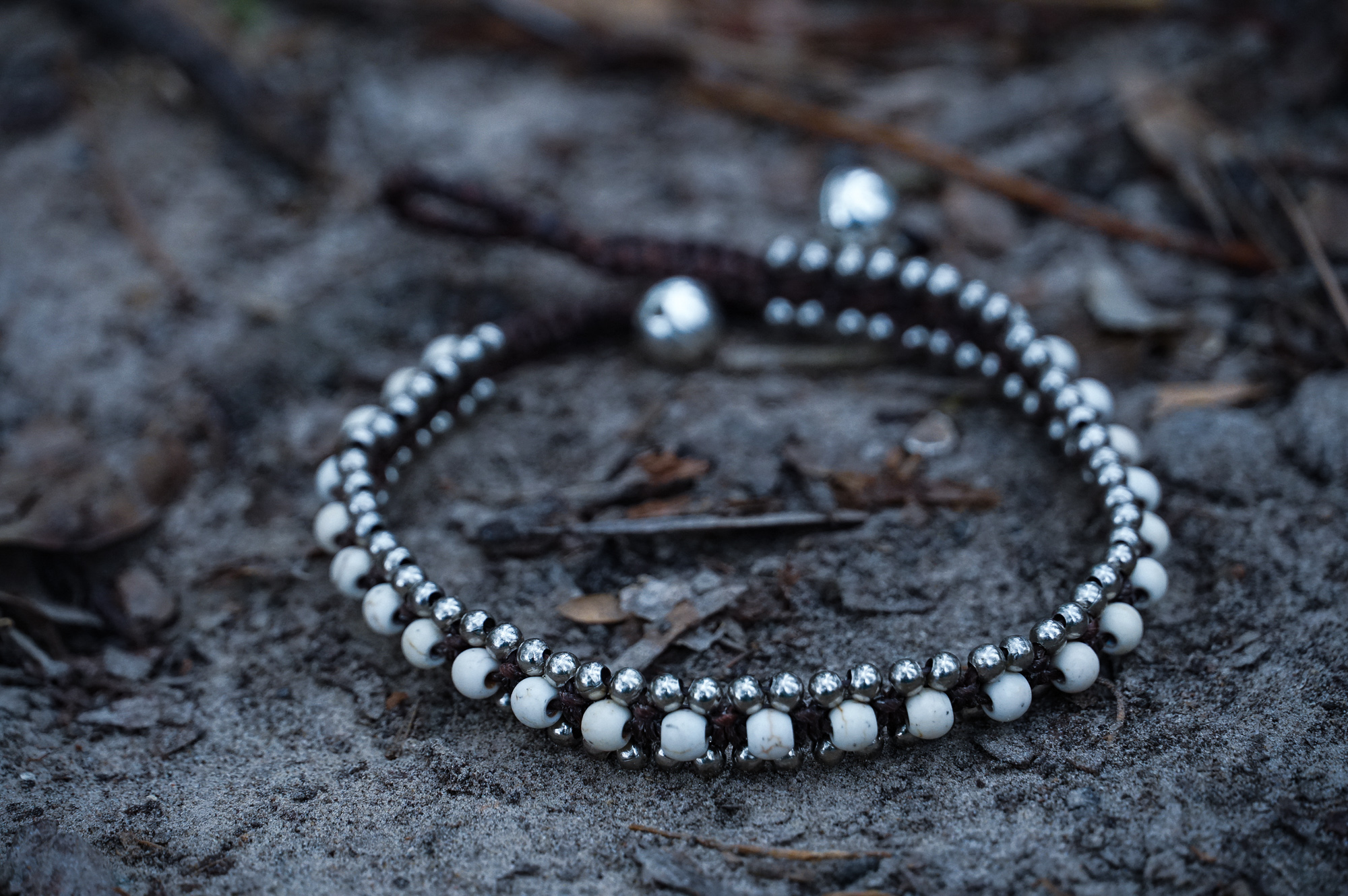 White Band Boho Silver Anklet featuring cotton chords, silver bells, and stone accents, handcrafted by Thai artisans.