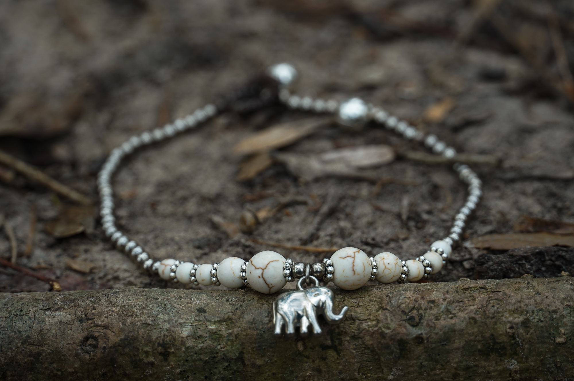 A beautiful White Elephant Pendant Boho Silver Anklet featuring silver bells and pressed cotton chords, perfect for bohemian style lovers.