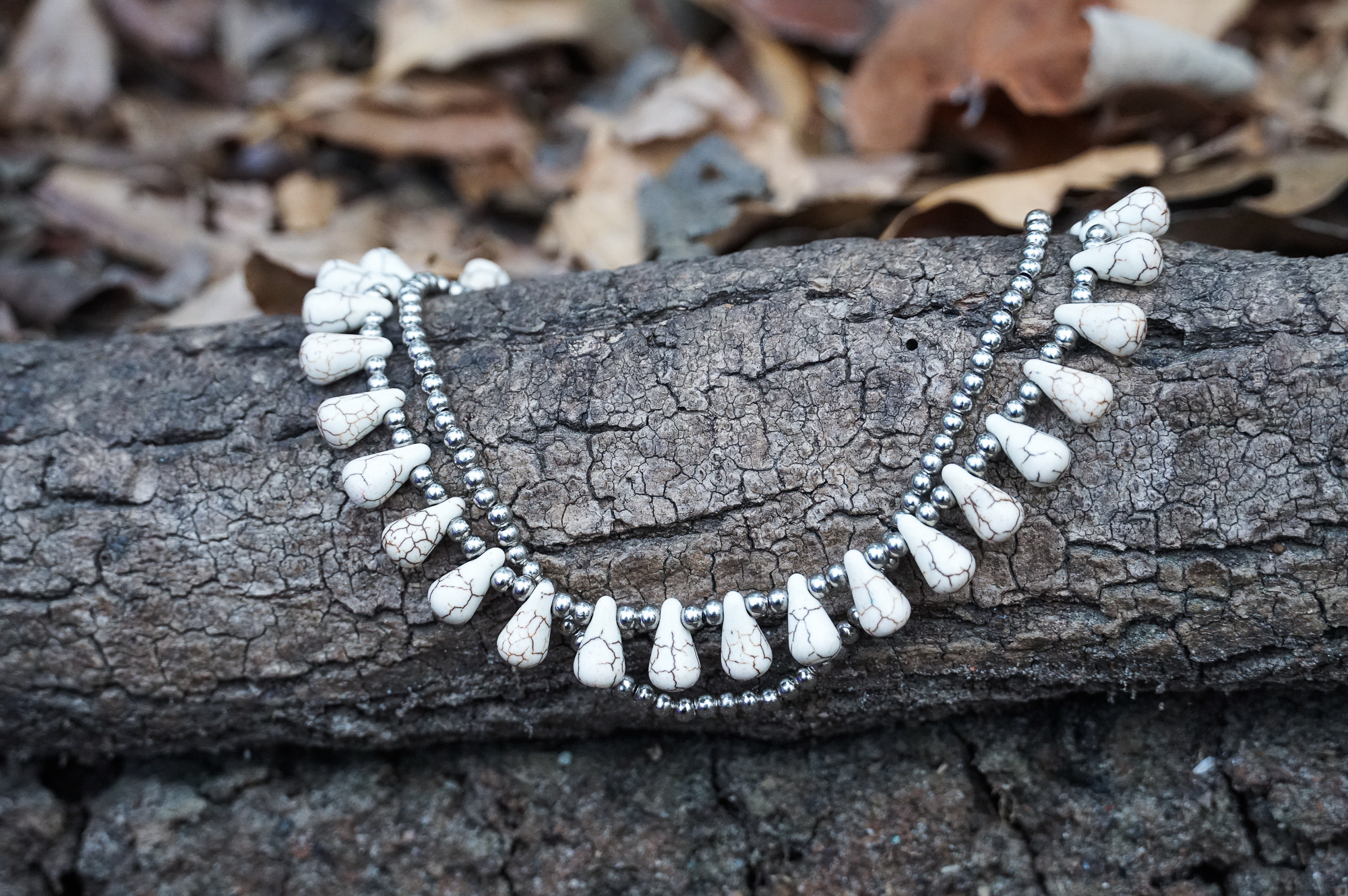 A beautiful White Teardrop Bead Boho Silver Anklet featuring silver bells and pressed cotton chords, handcrafted by Thai artisans.