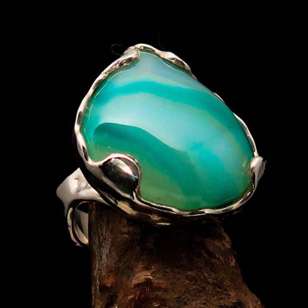 Artistic sterling silver ring featuring a pear-shaped green Agate cabochon, showcasing its elegant design and polished finish.