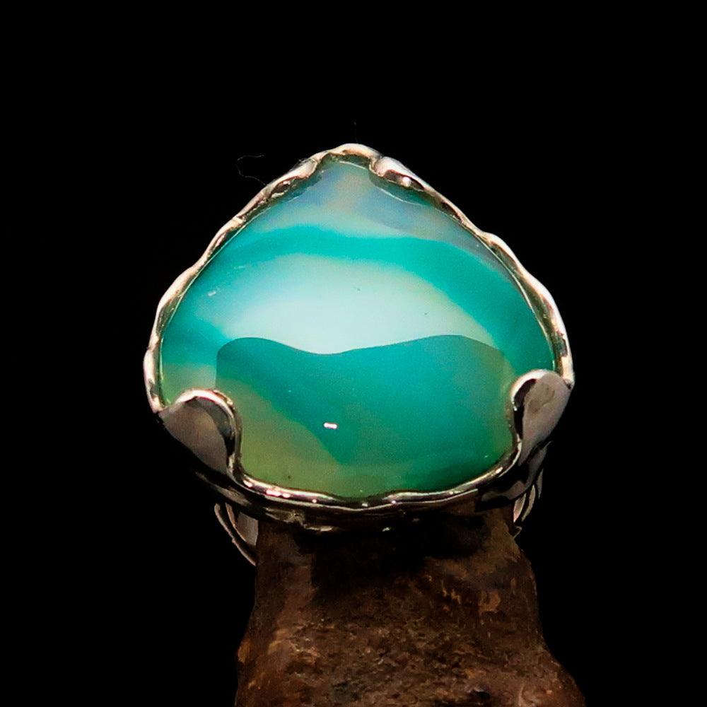 Artistic sterling silver ring featuring a pear-shaped green Agate cabochon, showcasing its elegant design and polished finish.