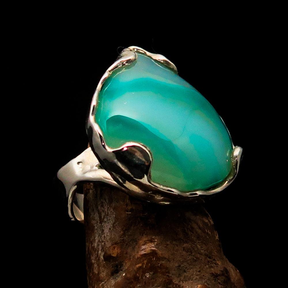 Artistic sterling silver ring featuring a pear-shaped green Agate cabochon, showcasing its elegant design and polished finish.