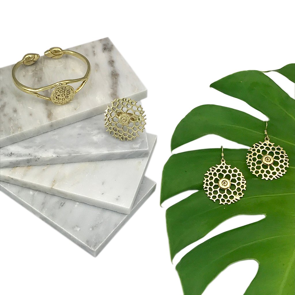 Gold jewelry on marble and leaf.