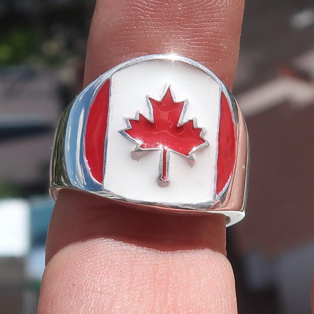 A beautifully crafted Canadian Flag Ring made of solid sterling silver with vibrant enamel detailing, showcasing the national flag of Canada.