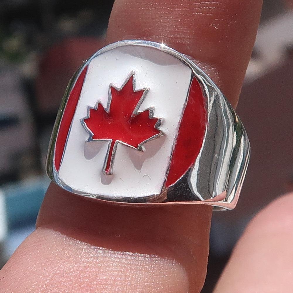 A beautifully crafted Canadian Flag Ring made of solid sterling silver with vibrant enamel detailing, showcasing the national flag of Canada.