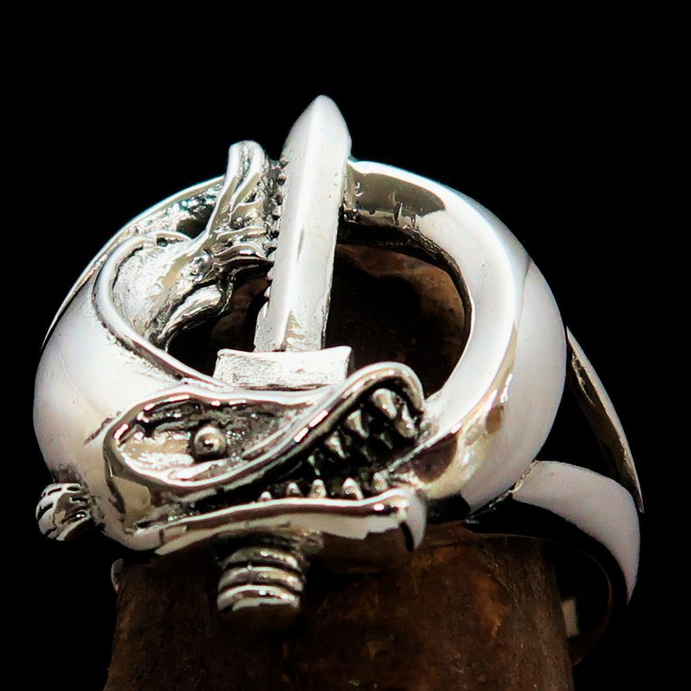 A beautifully crafted sterling silver ring featuring intricate fish and sword designs, showcasing a high polished finish.