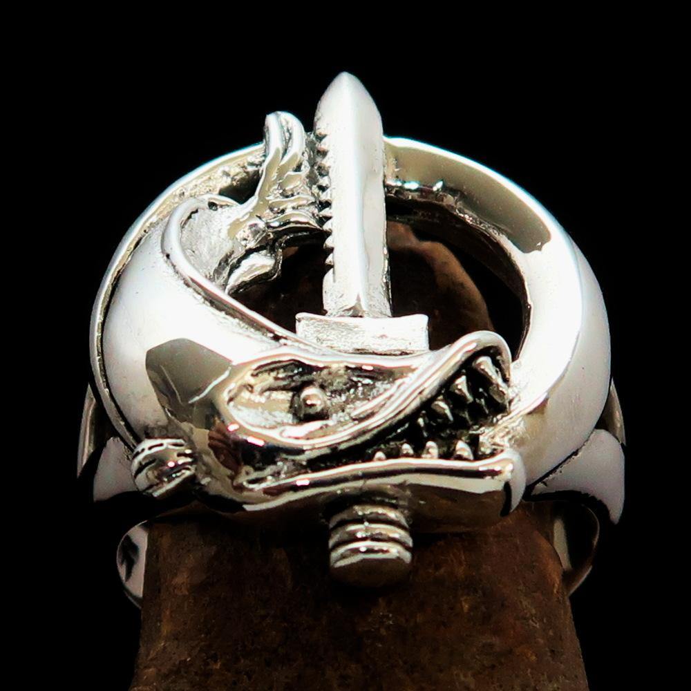 A beautifully crafted sterling silver ring featuring intricate fish and sword designs, showcasing a high polished finish.